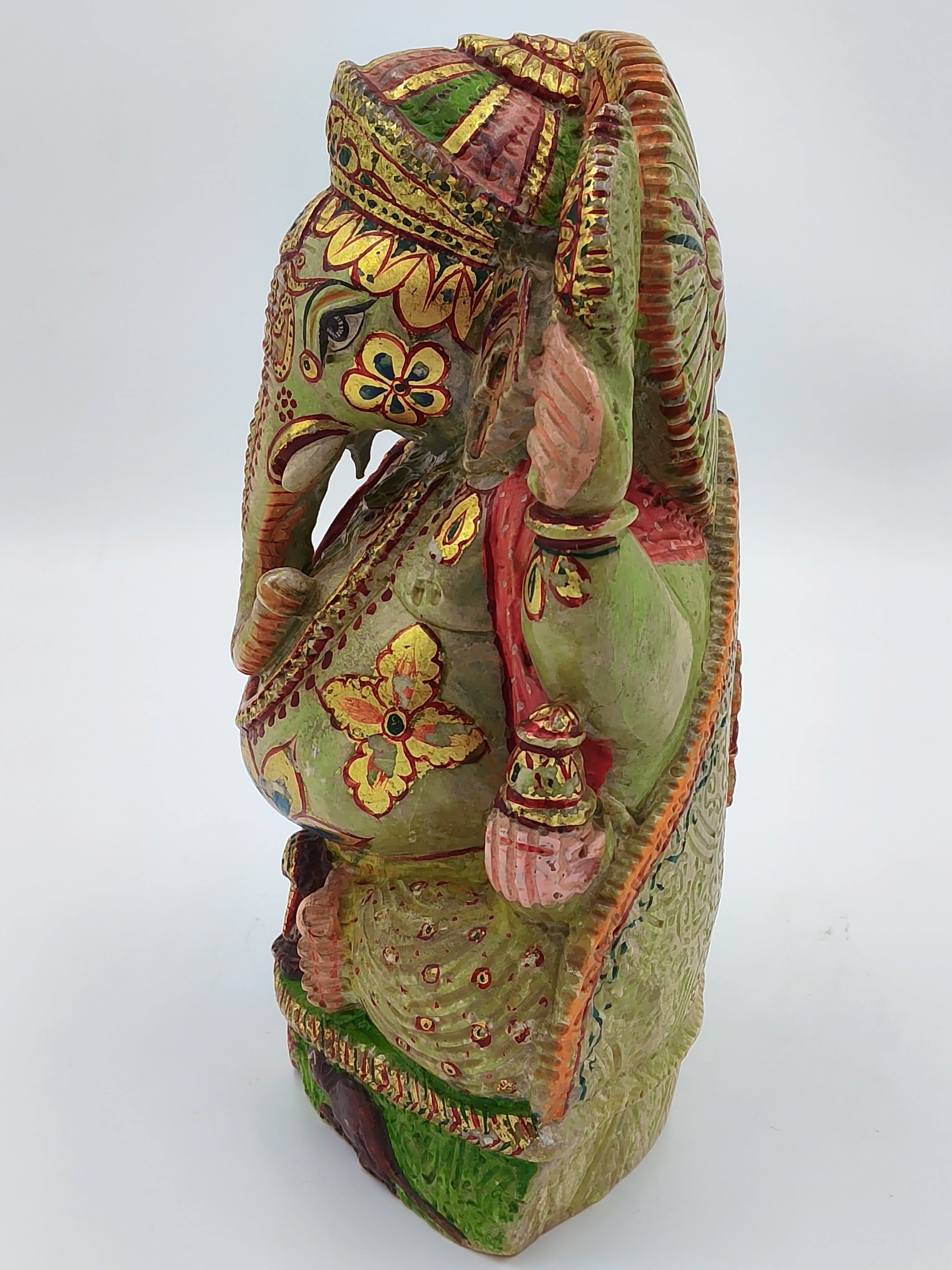 Side view of painted Serpentine Ganesh statue with floral designs