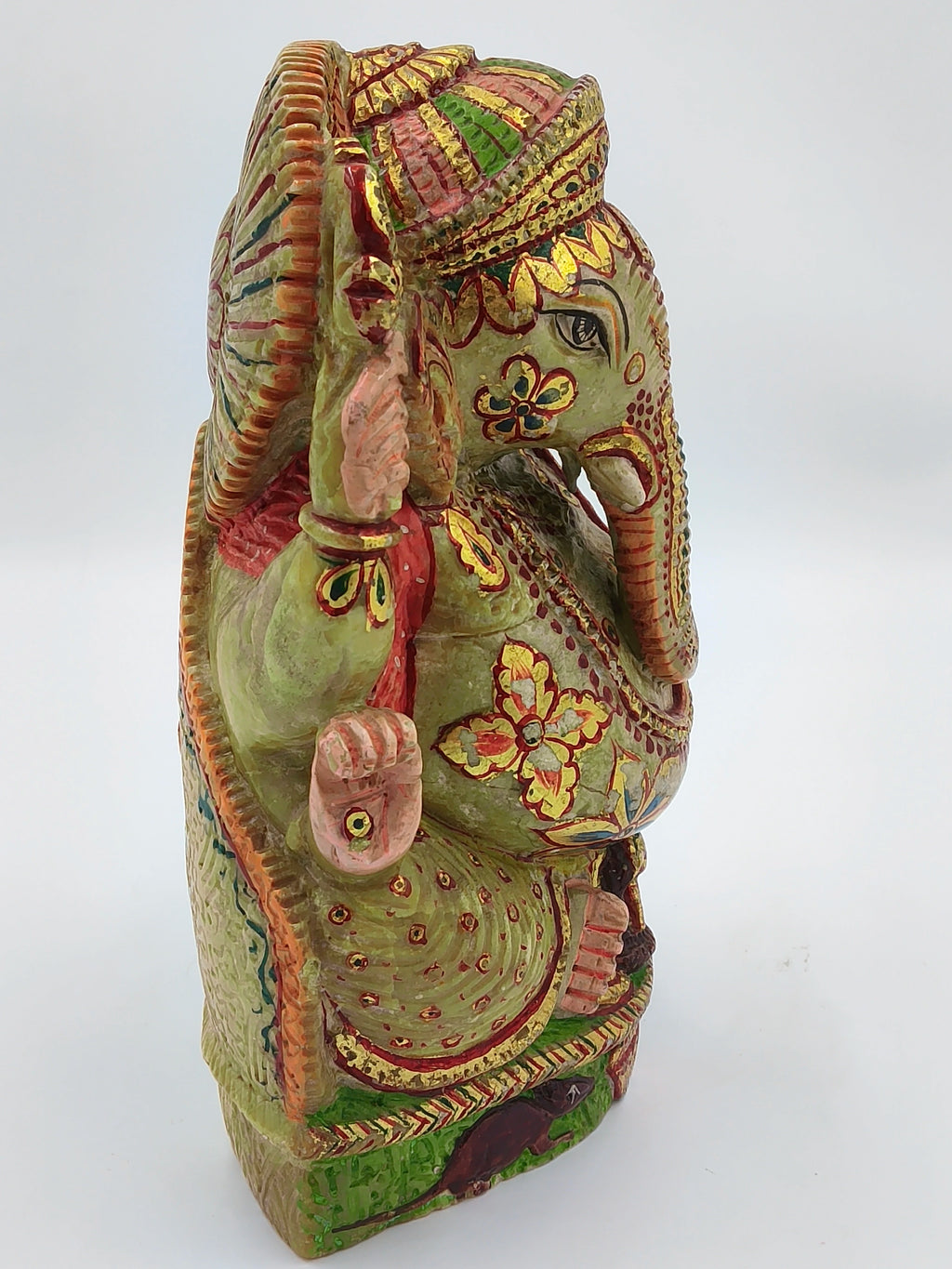 Side view of painted serpentine sculpture of Ganesh with intricate floral patterns