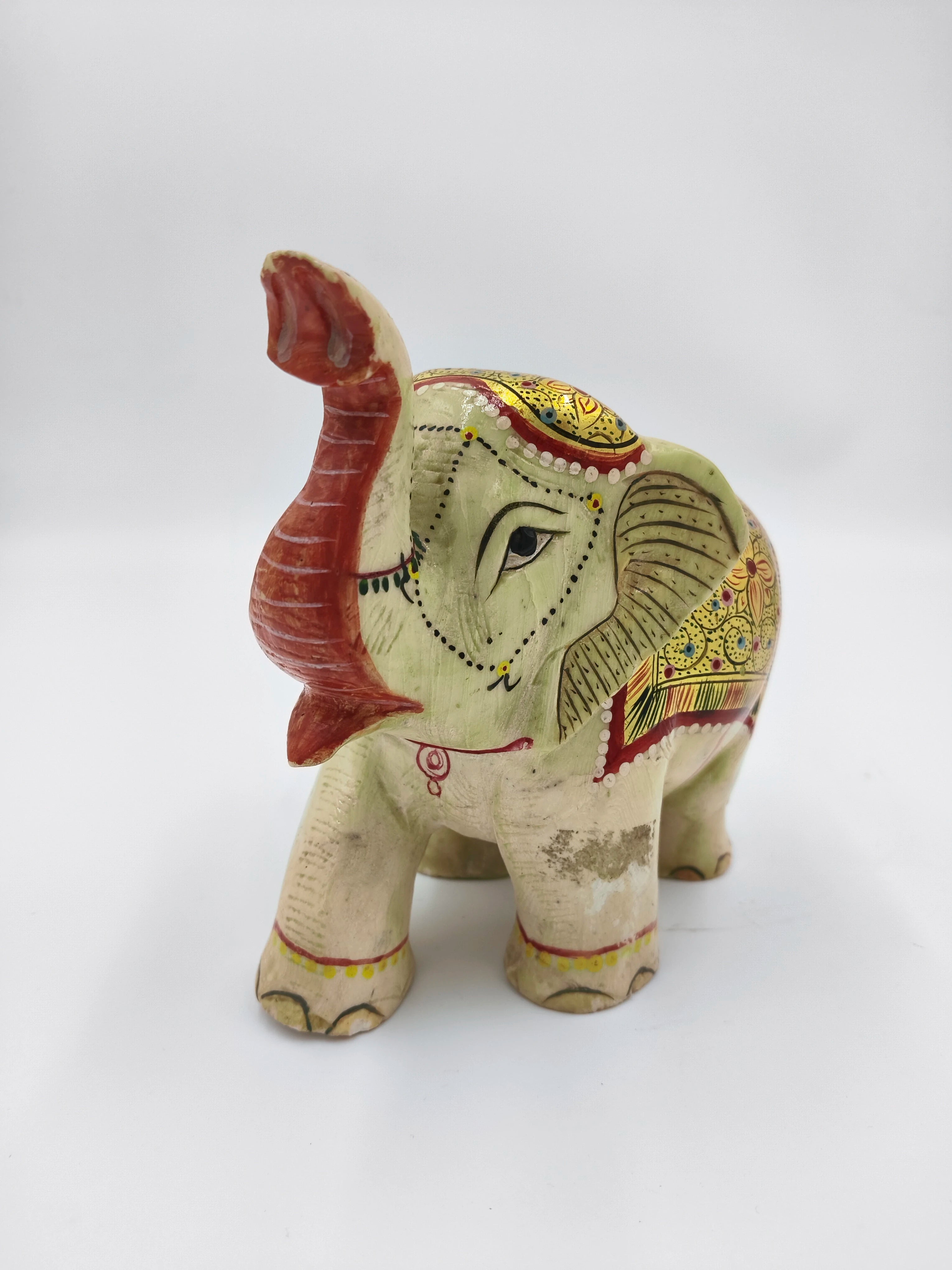 Hand-painted serpentine elephant sculpture with raised trunk and decorative patterns