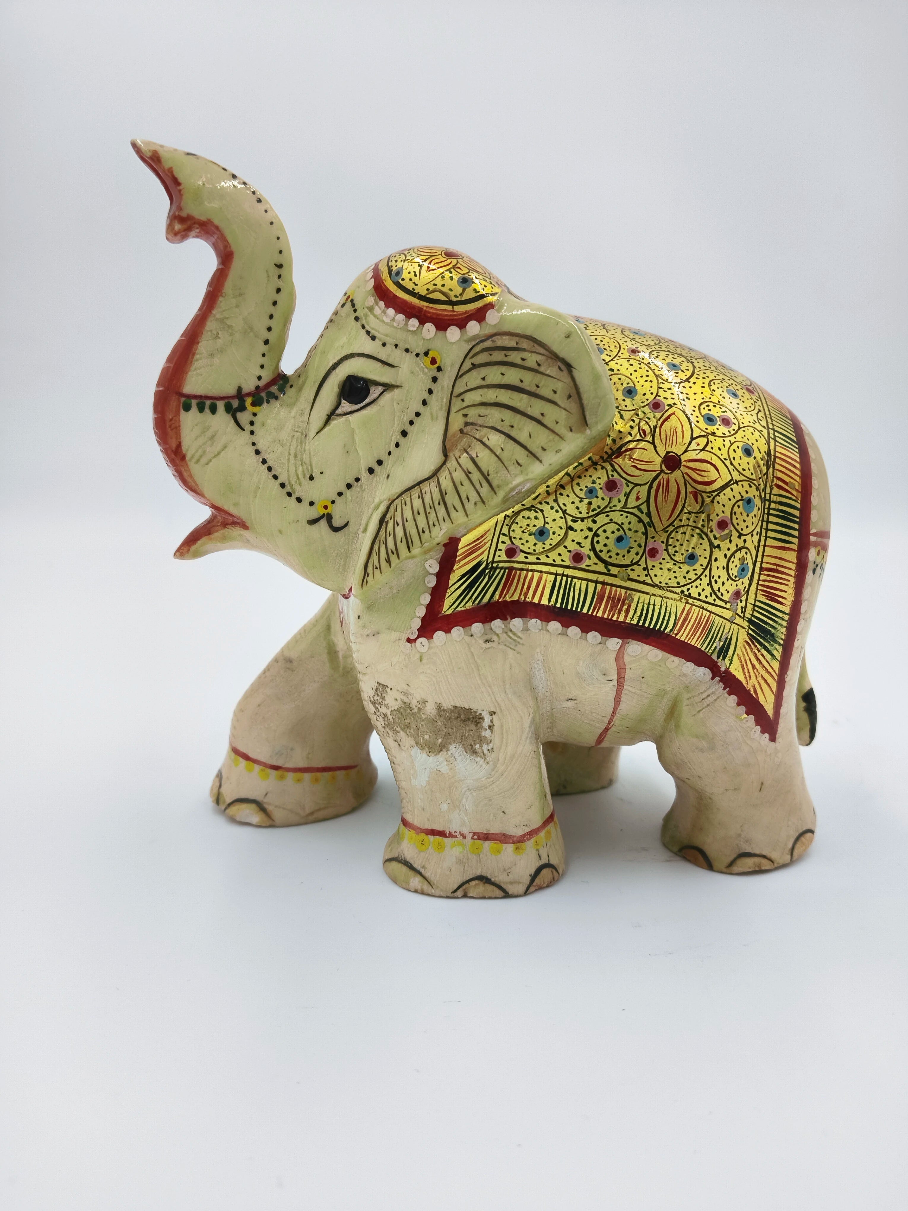 Side view of a serpentine elephant sculpture with red and gold decorative patterns