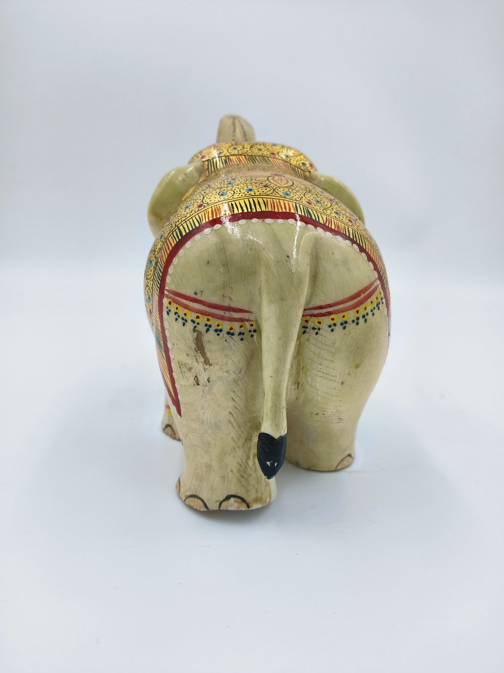 Rear view of hand-painted serpentine elephant sculpture with decorative patterns