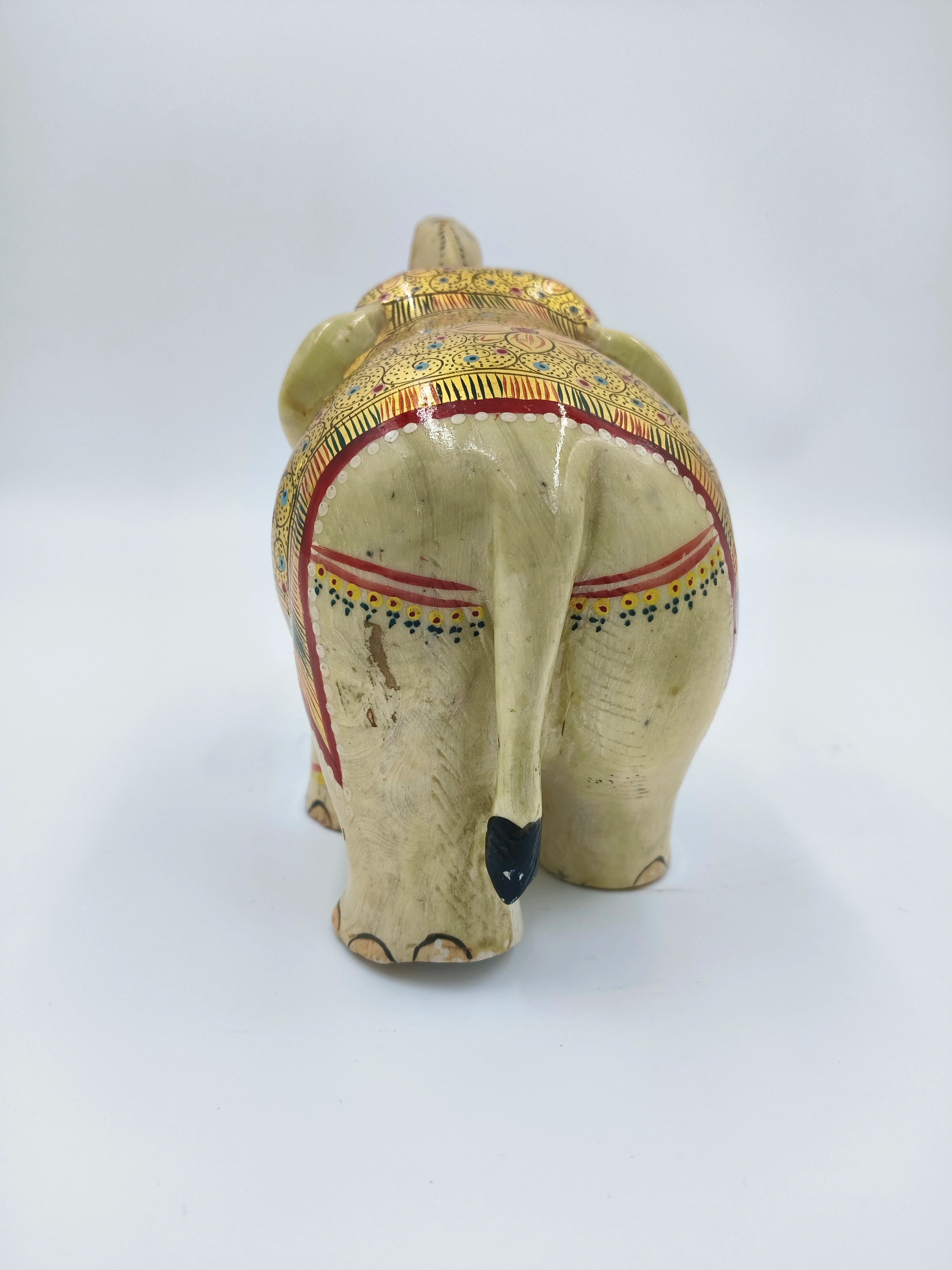 Rear view of hand-painted serpentine elephant sculpture with decorative patterns