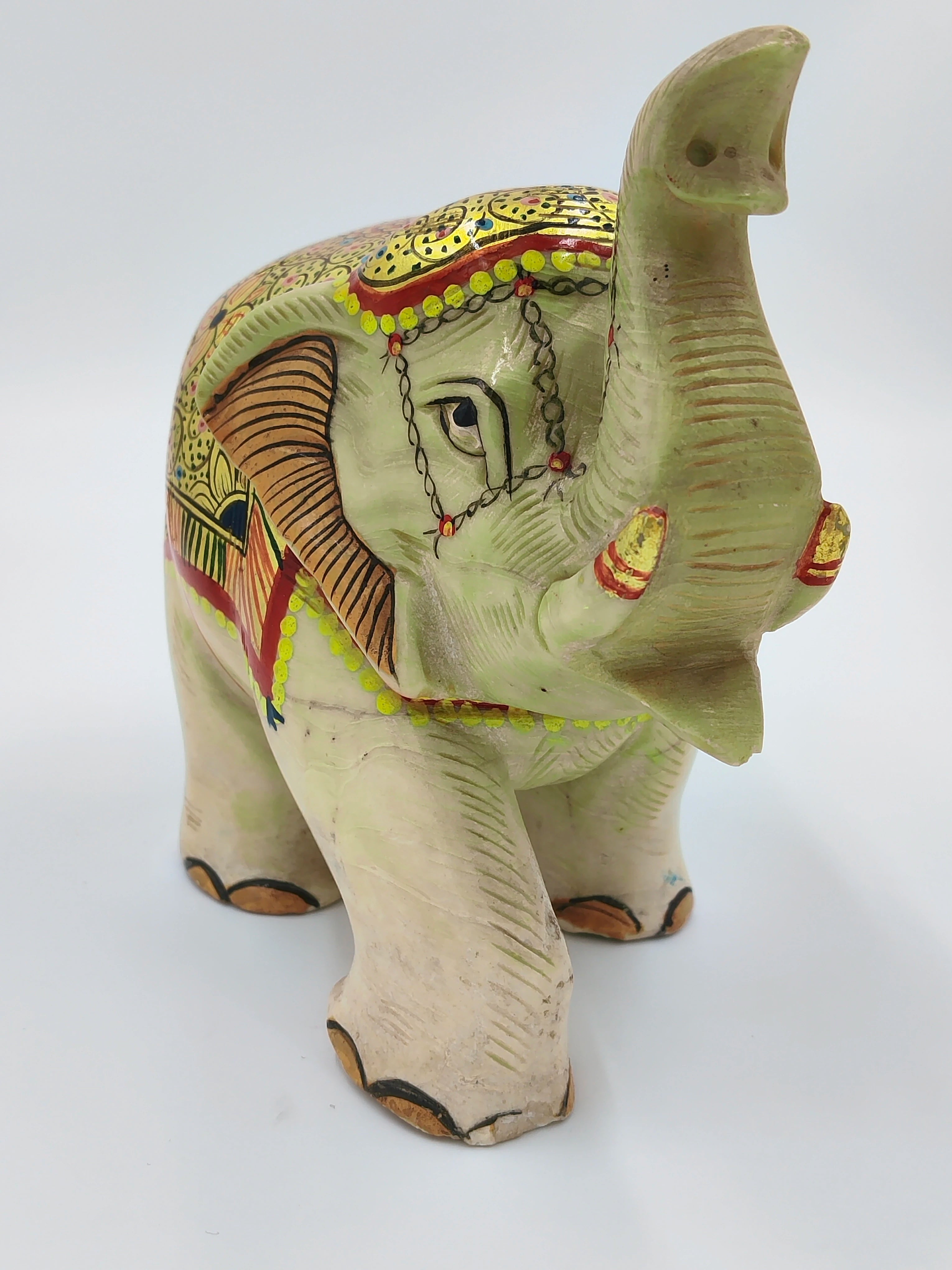 Serpentine elephant sculpture with painted decorative patterns, front view