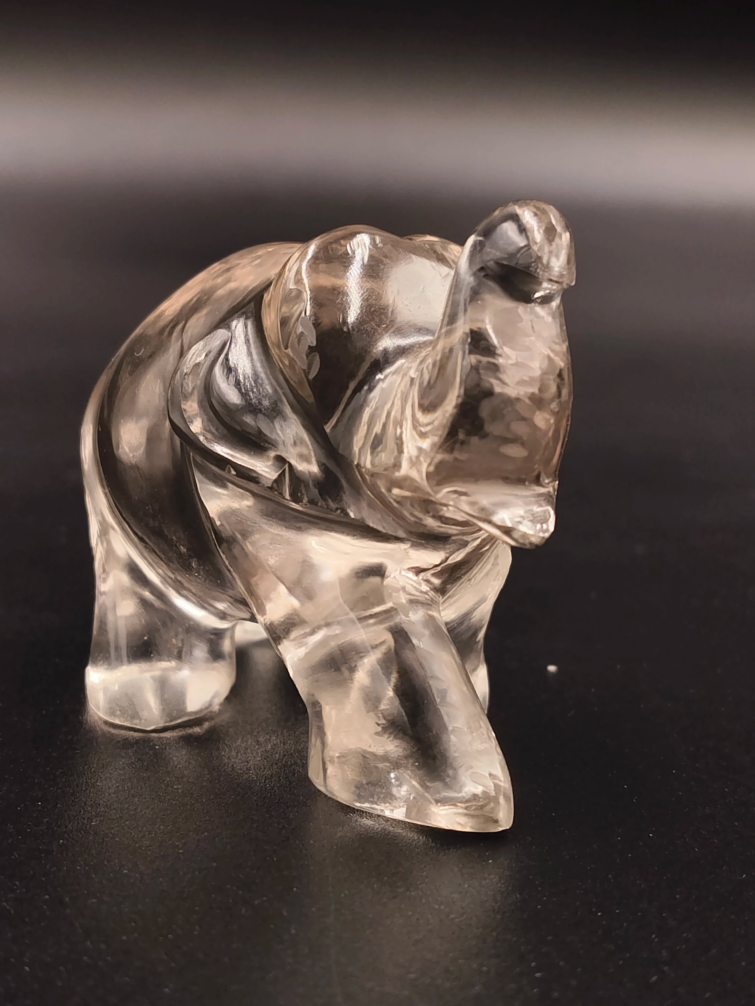 Clear crystal elephant figurine sculpture on black surface front view