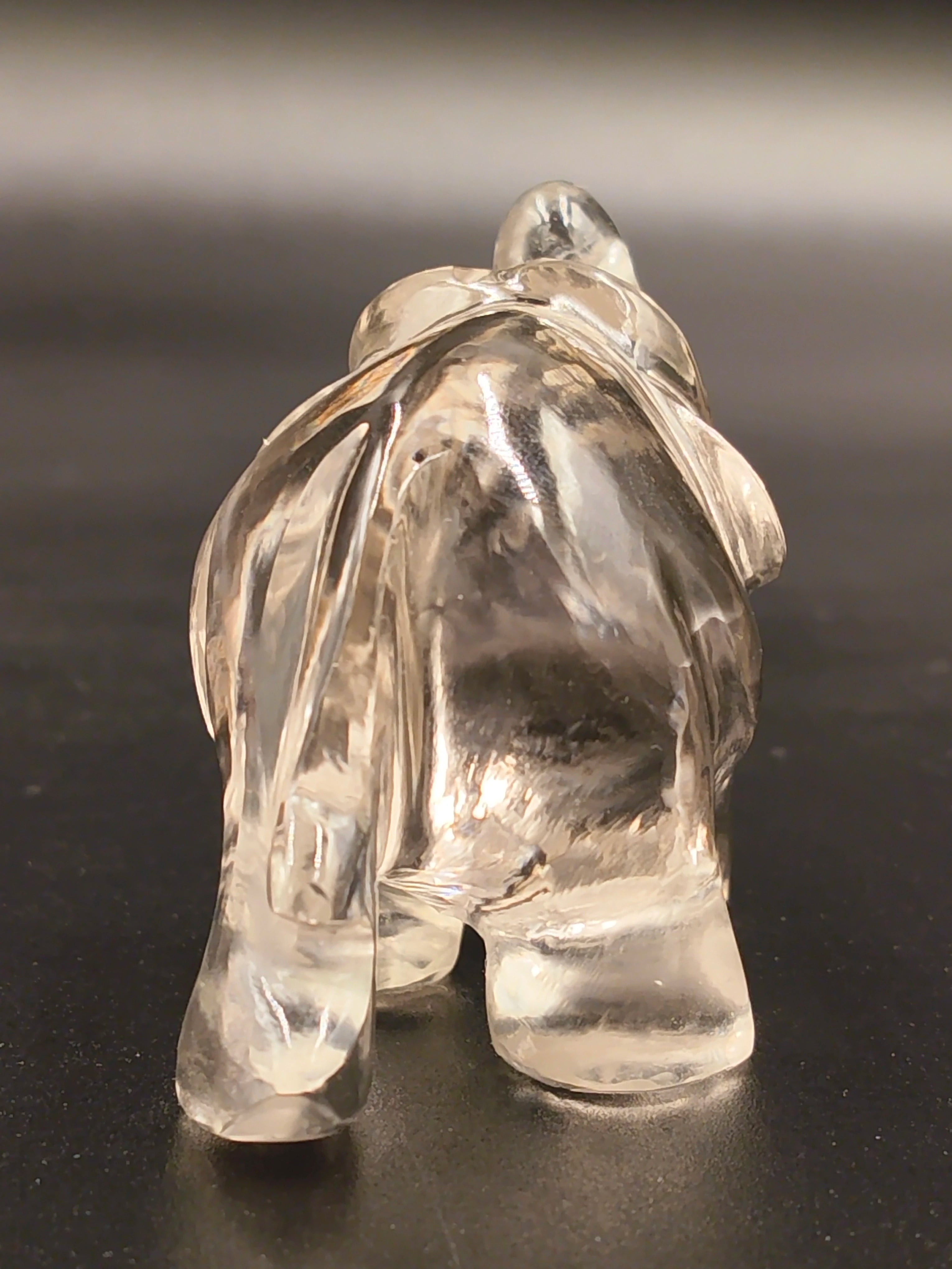 Rear view of a small clear crystal elephant figurine sculpture