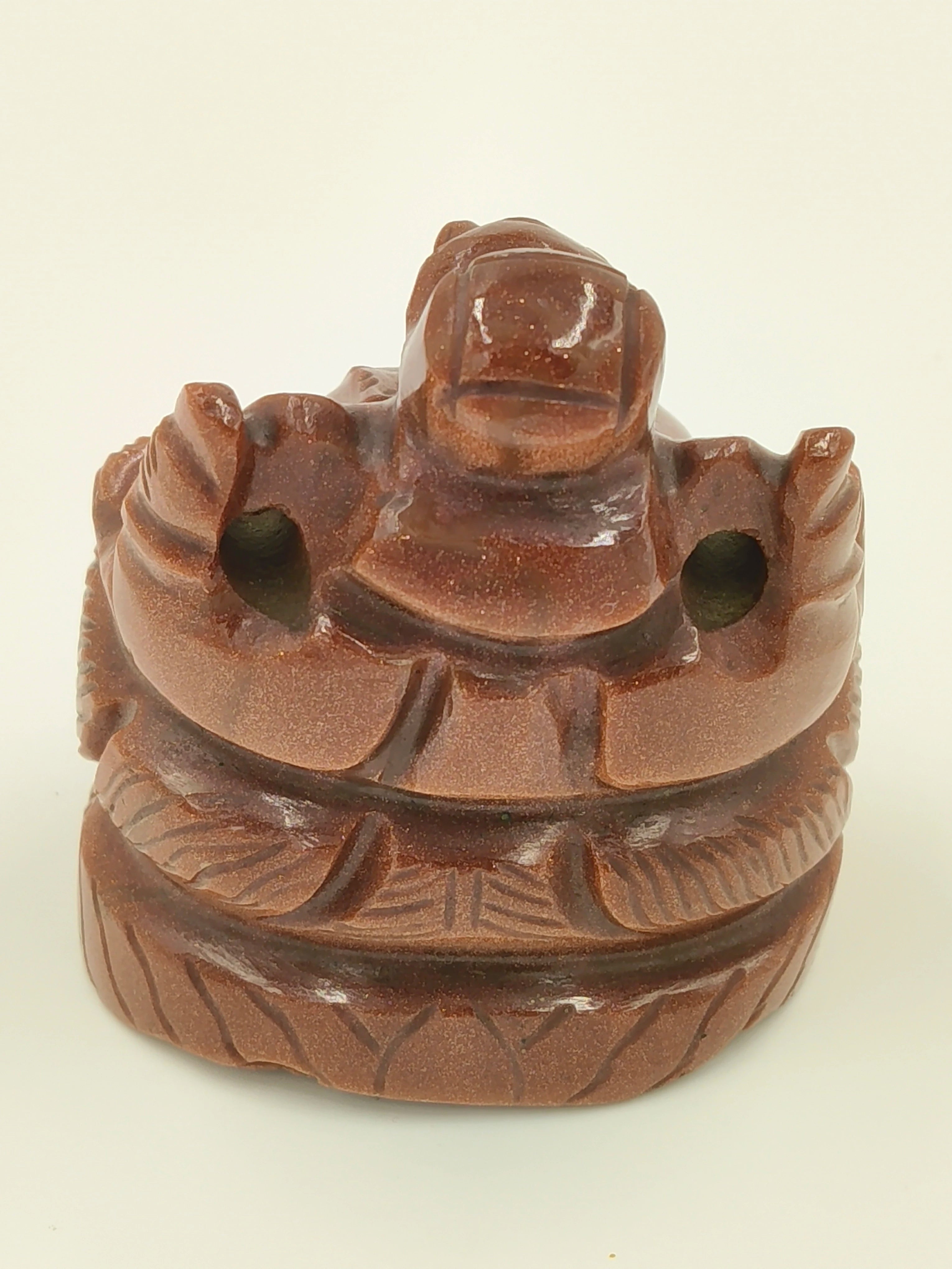 Small brown sunstone Ganesha sculpture seated on a carved base