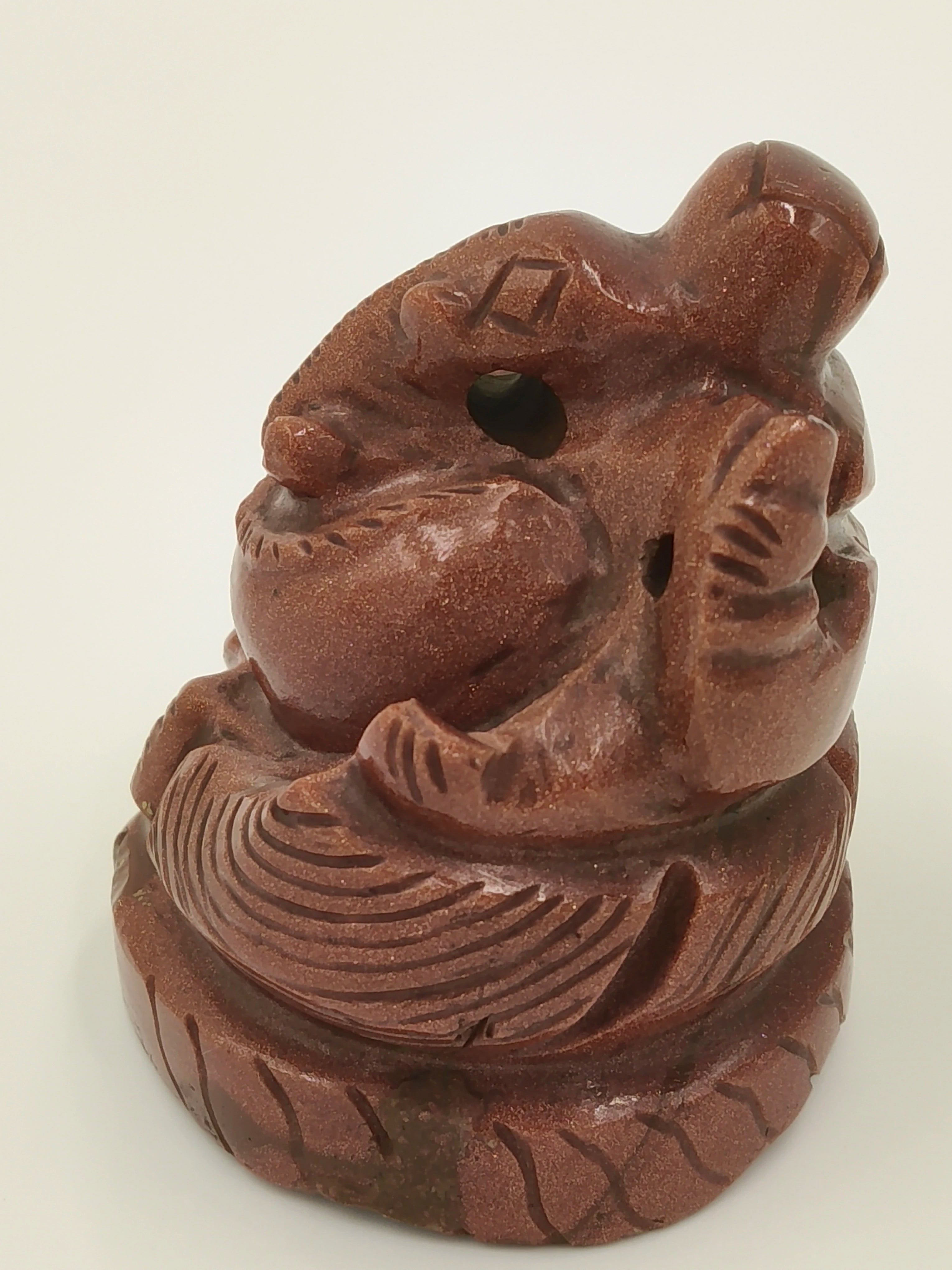 Small sunstone Ganesh sculpture with carved details on circular base