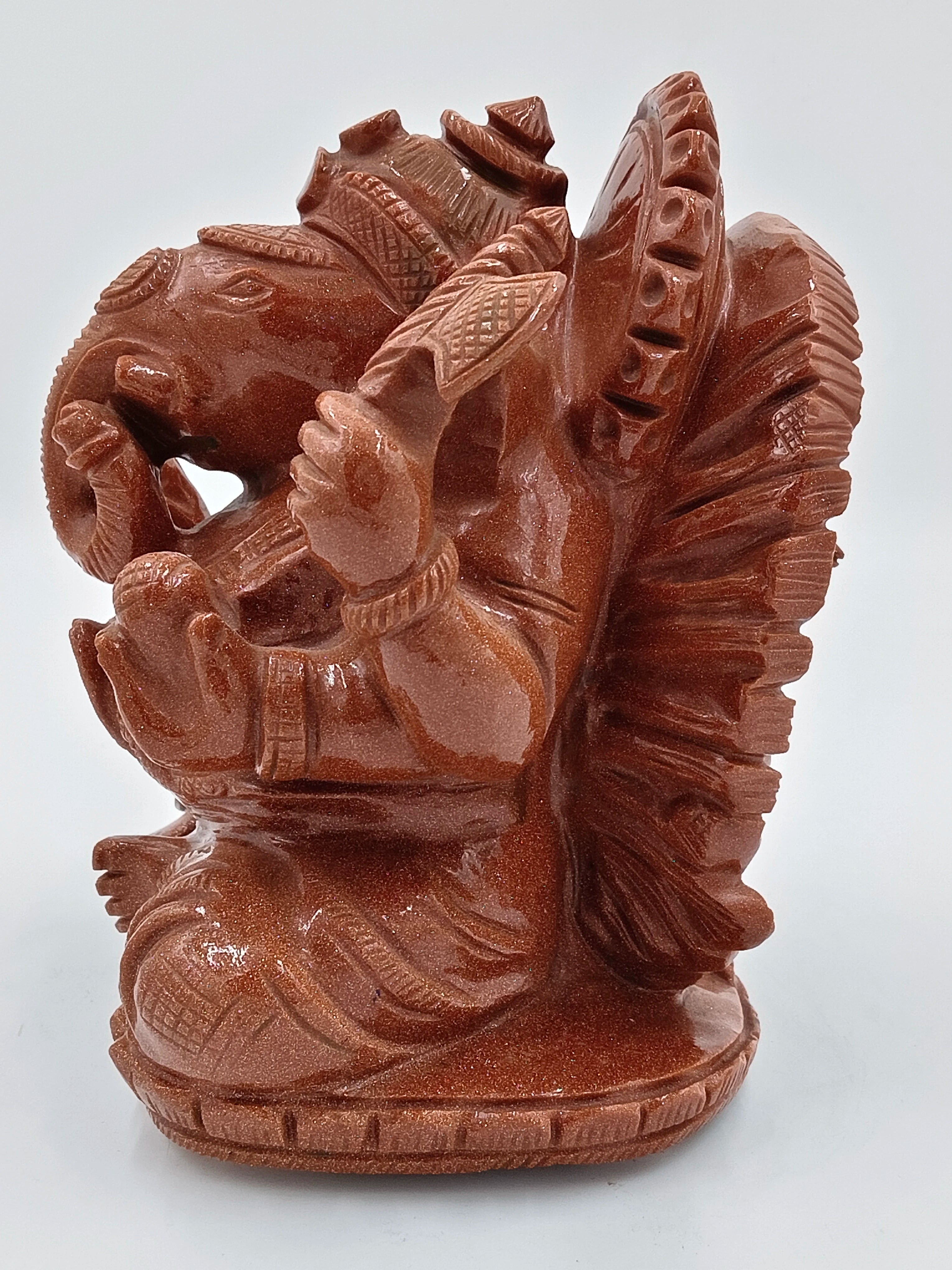 Sunstone sculpture of seated Ganesh deity with detailed carvings, side view