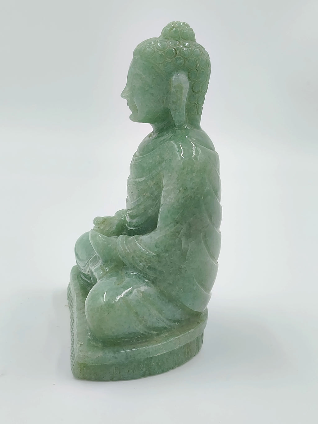 Side view of a 4.3-inch jade Buddha sculpture in seated meditation pose