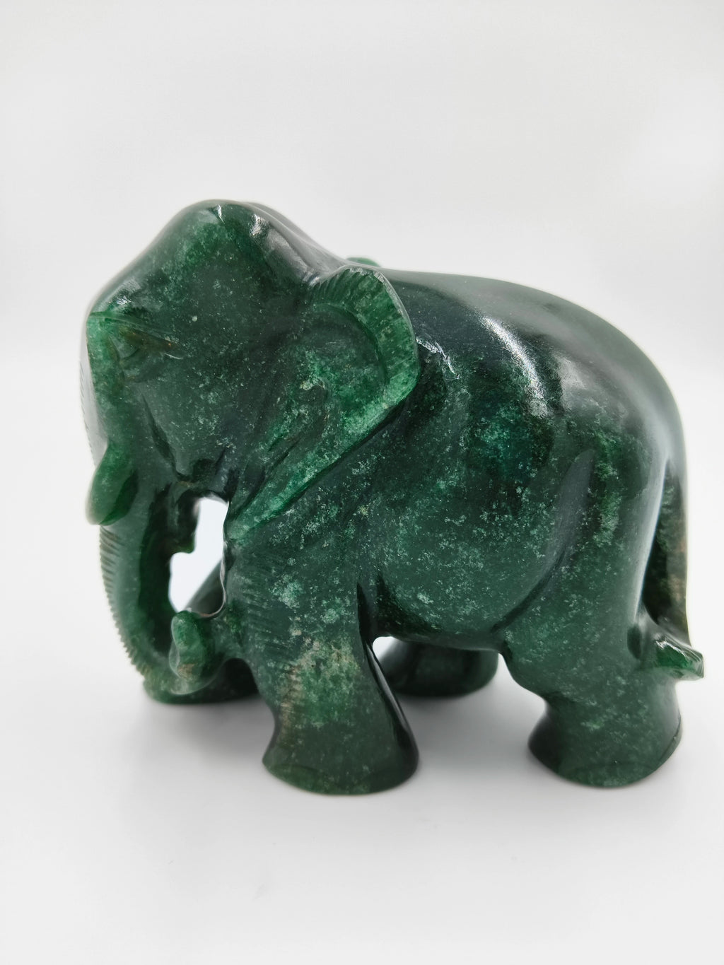 Small green jade elephant figurine sculpture facing left