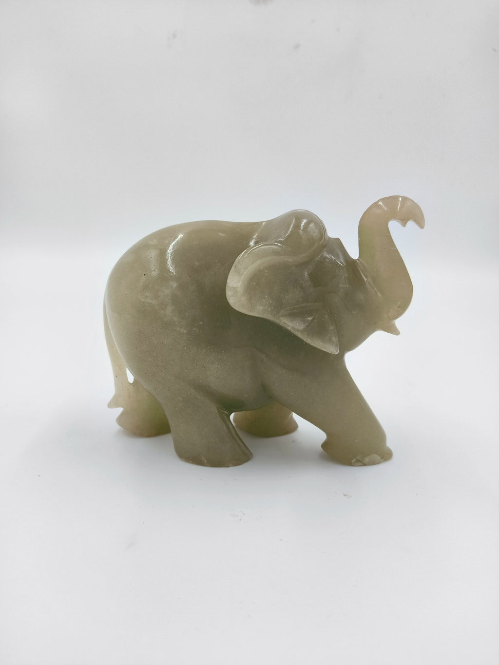 Small jade elephant figurine with raised trunk, side view