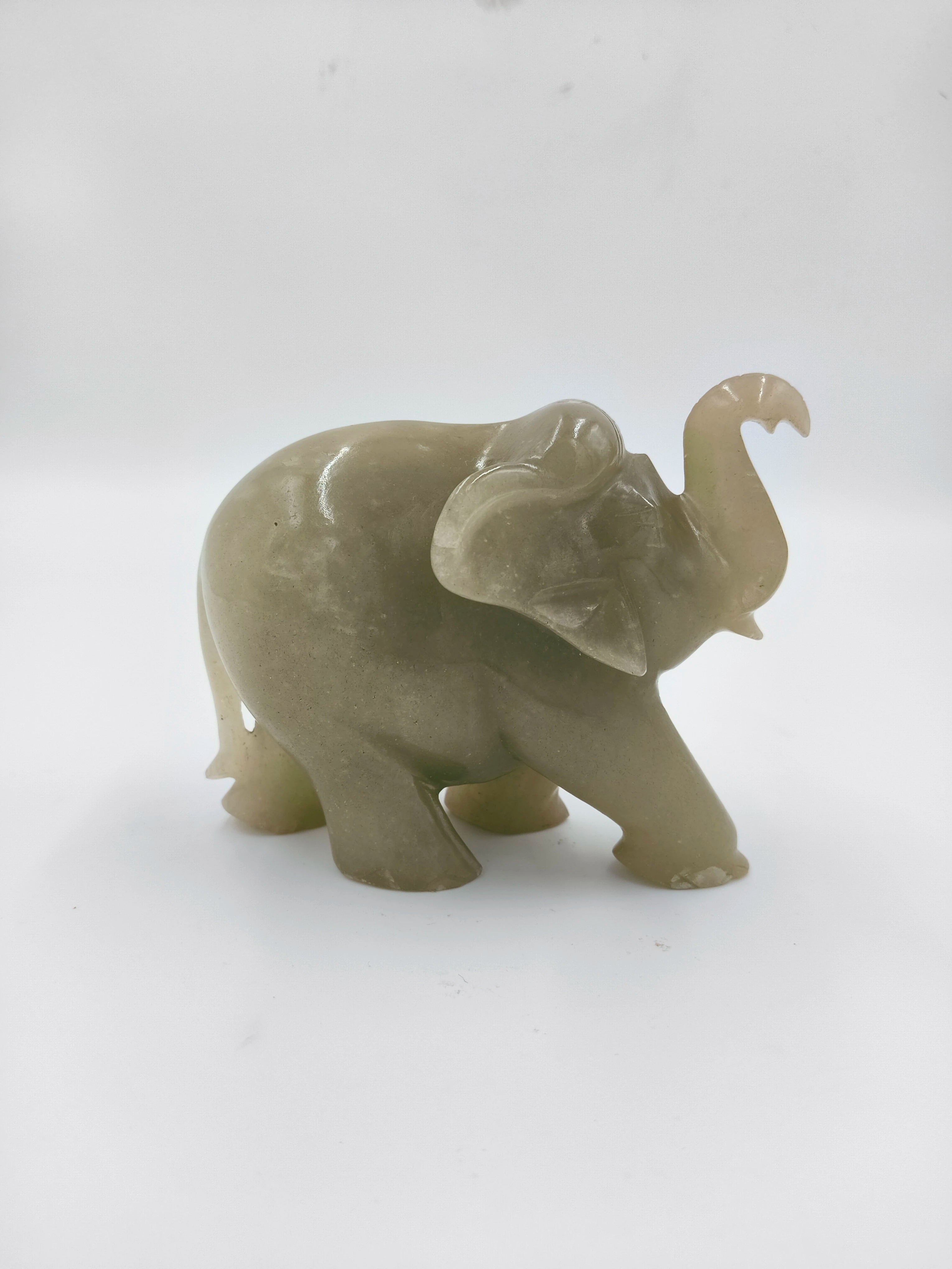 Small jade elephant figurine with raised trunk, side view