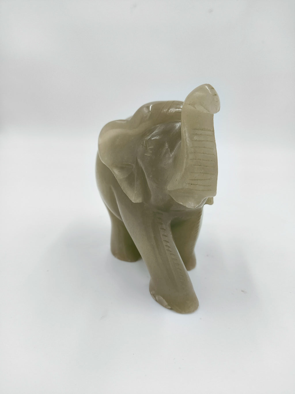 Small jade elephant figurine sculpture with raised trunk, tabletop decor