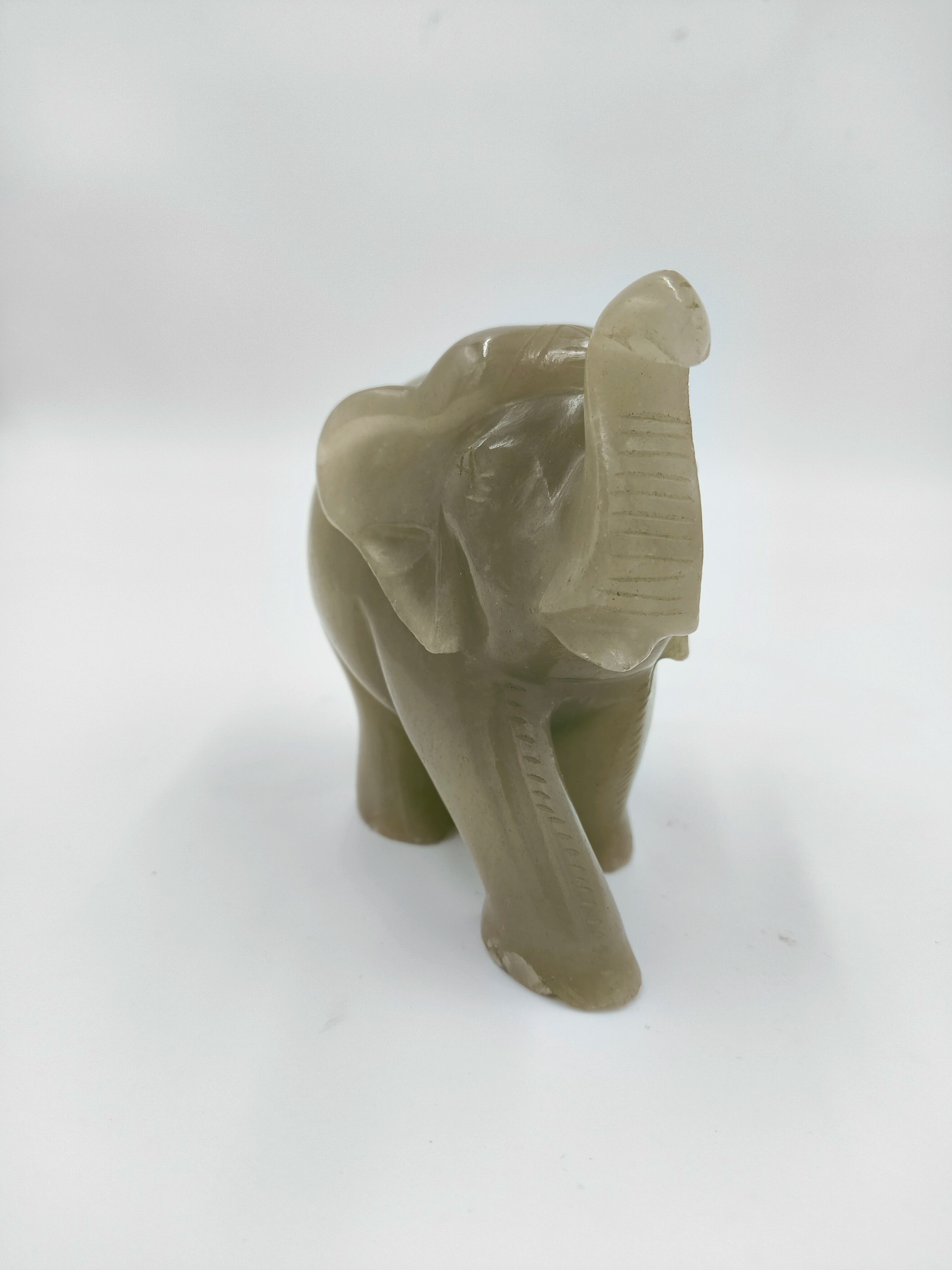 Small jade elephant figurine sculpture with raised trunk, tabletop decor
