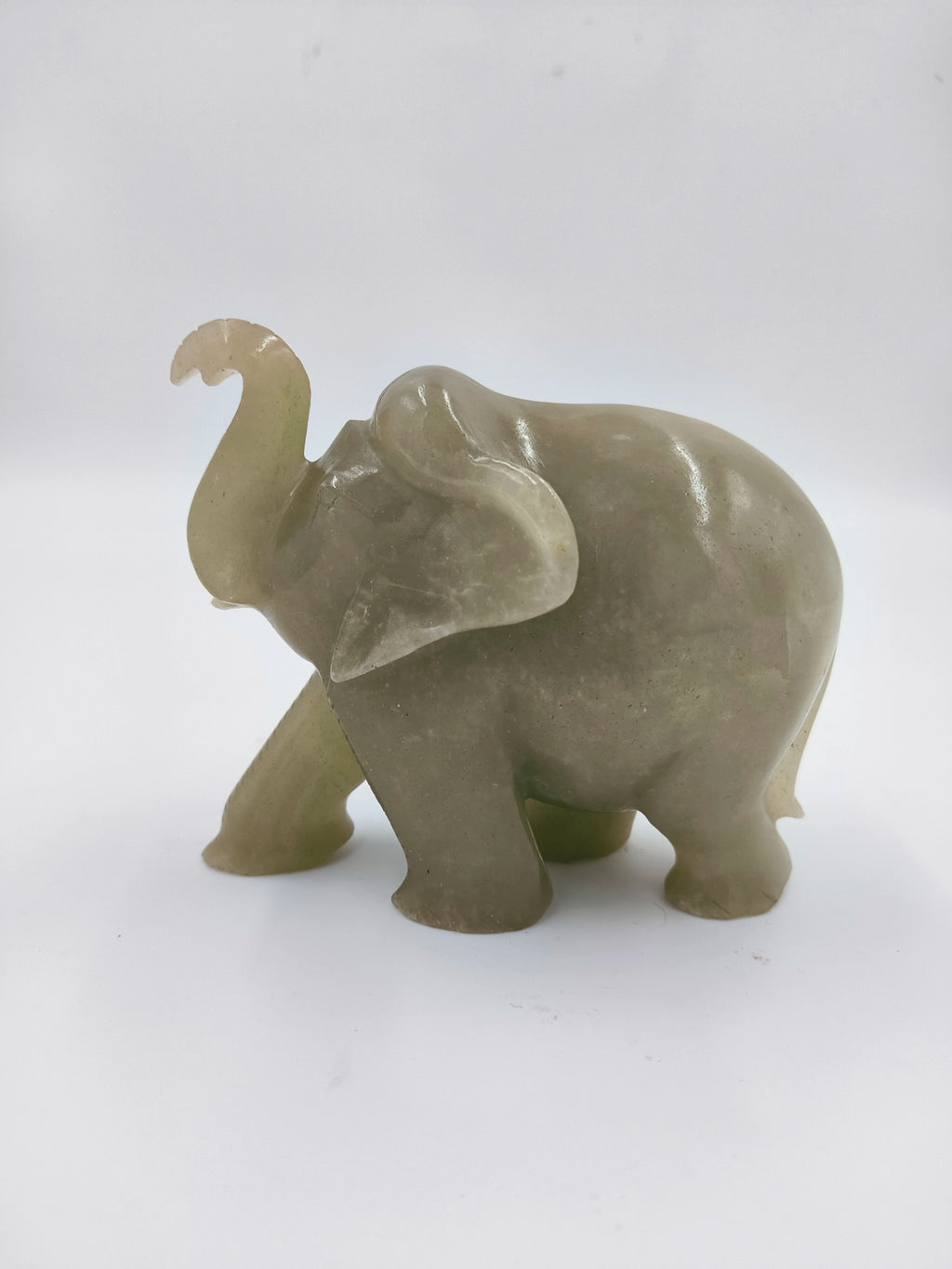 Small jade elephant figurine with raised trunk, side view