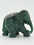 Green jade elephant sculpture with raised trunk holding a ball