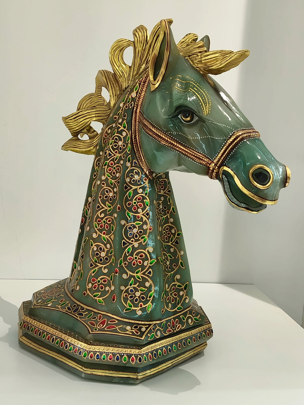 Large jade horse head sculpture with gold accents and colorful floral paintings