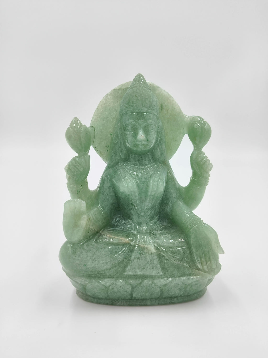 Jade statue of goddess Lakshmi seated in lotus position with four arms