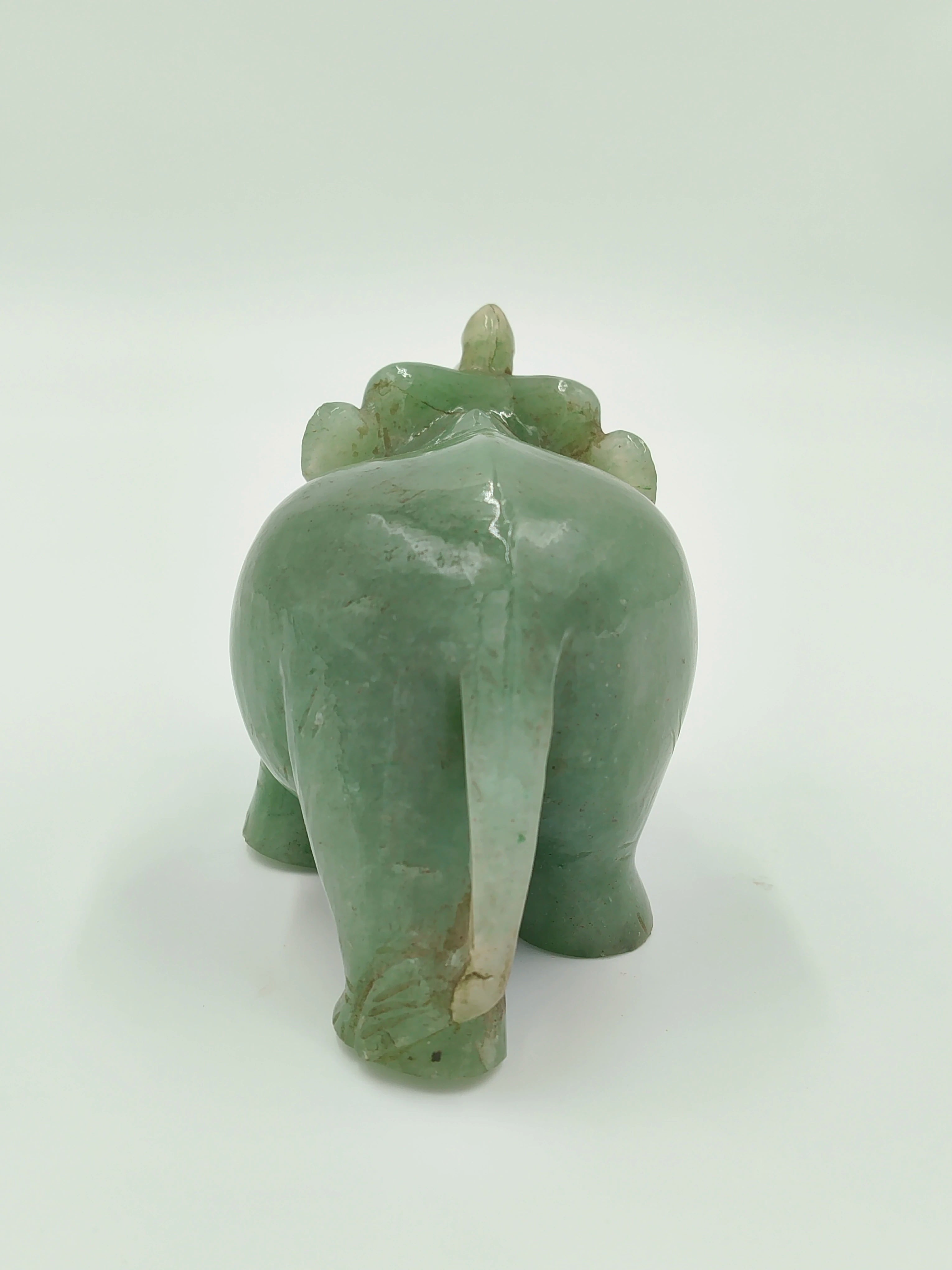 Back view of a small green jade elephant figurine sculpture