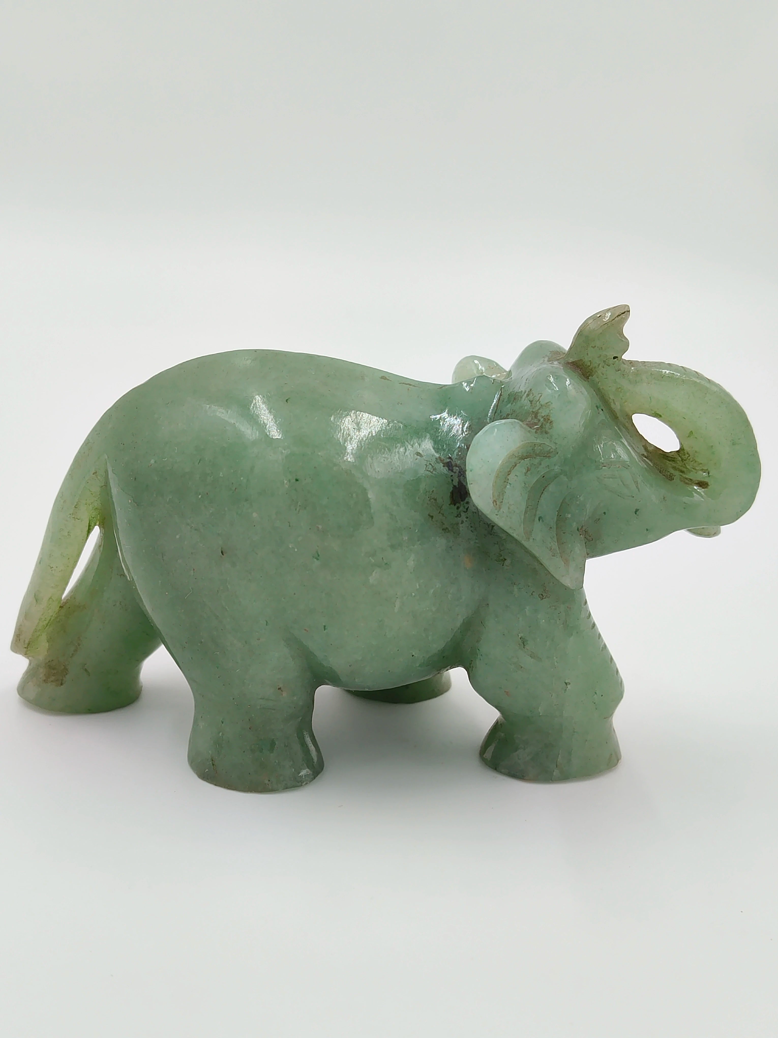 Small jade elephant sculpture with raised trunk, side view