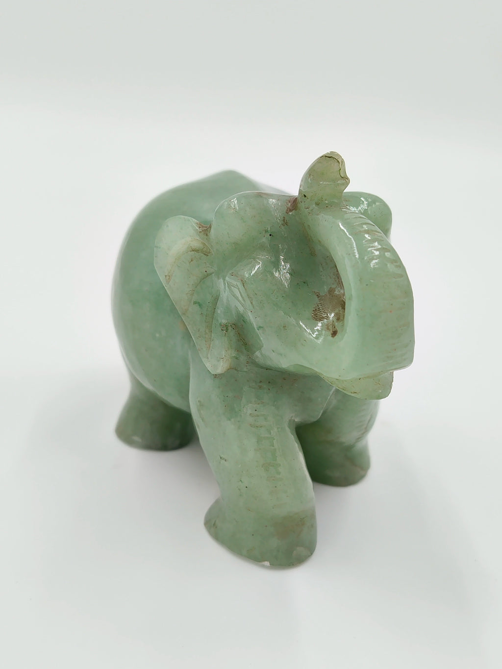 Small jade elephant sculpture with raised trunk and carved details