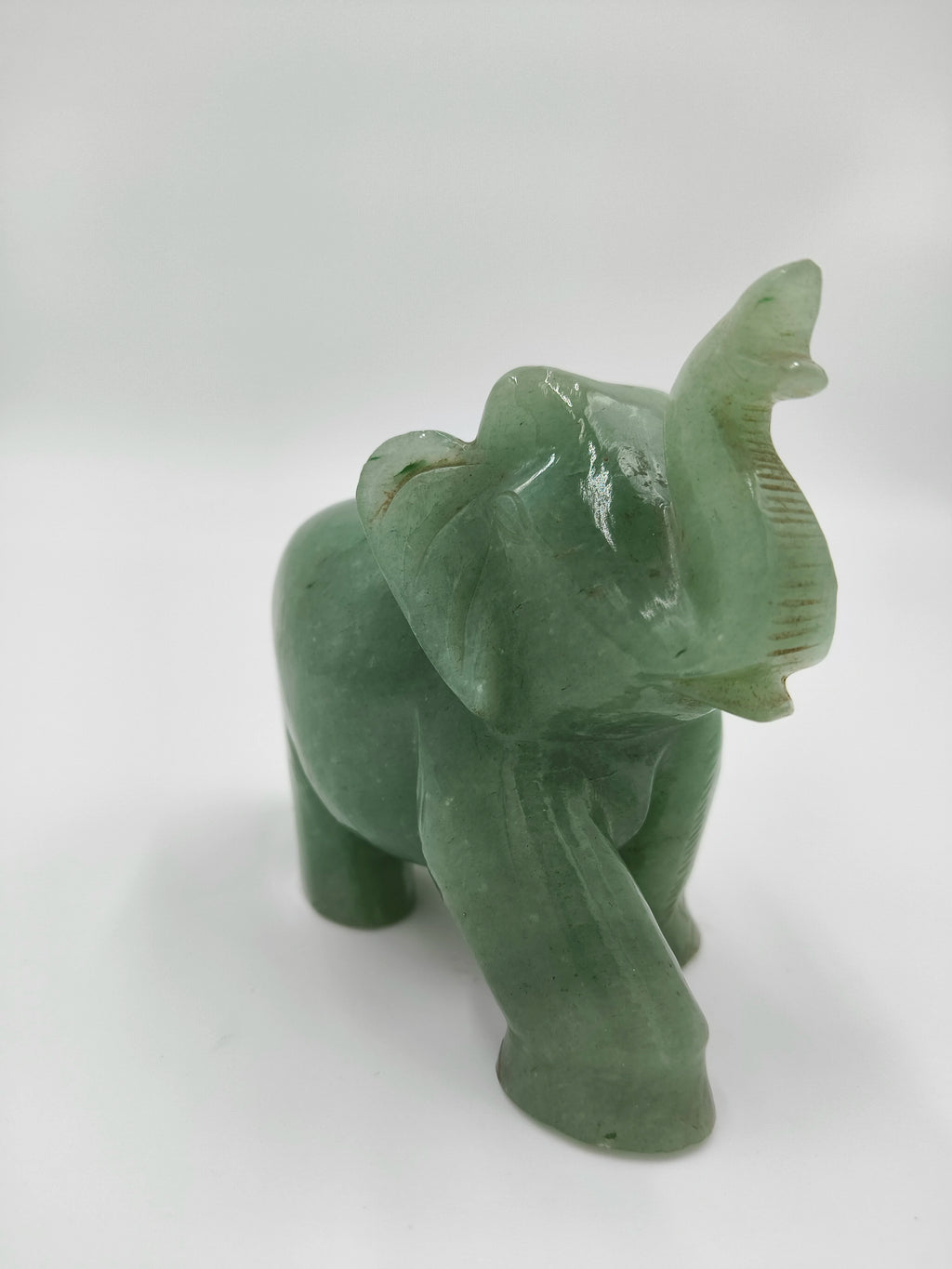 Small green jade elephant sculpture with raised trunk tabletop decor