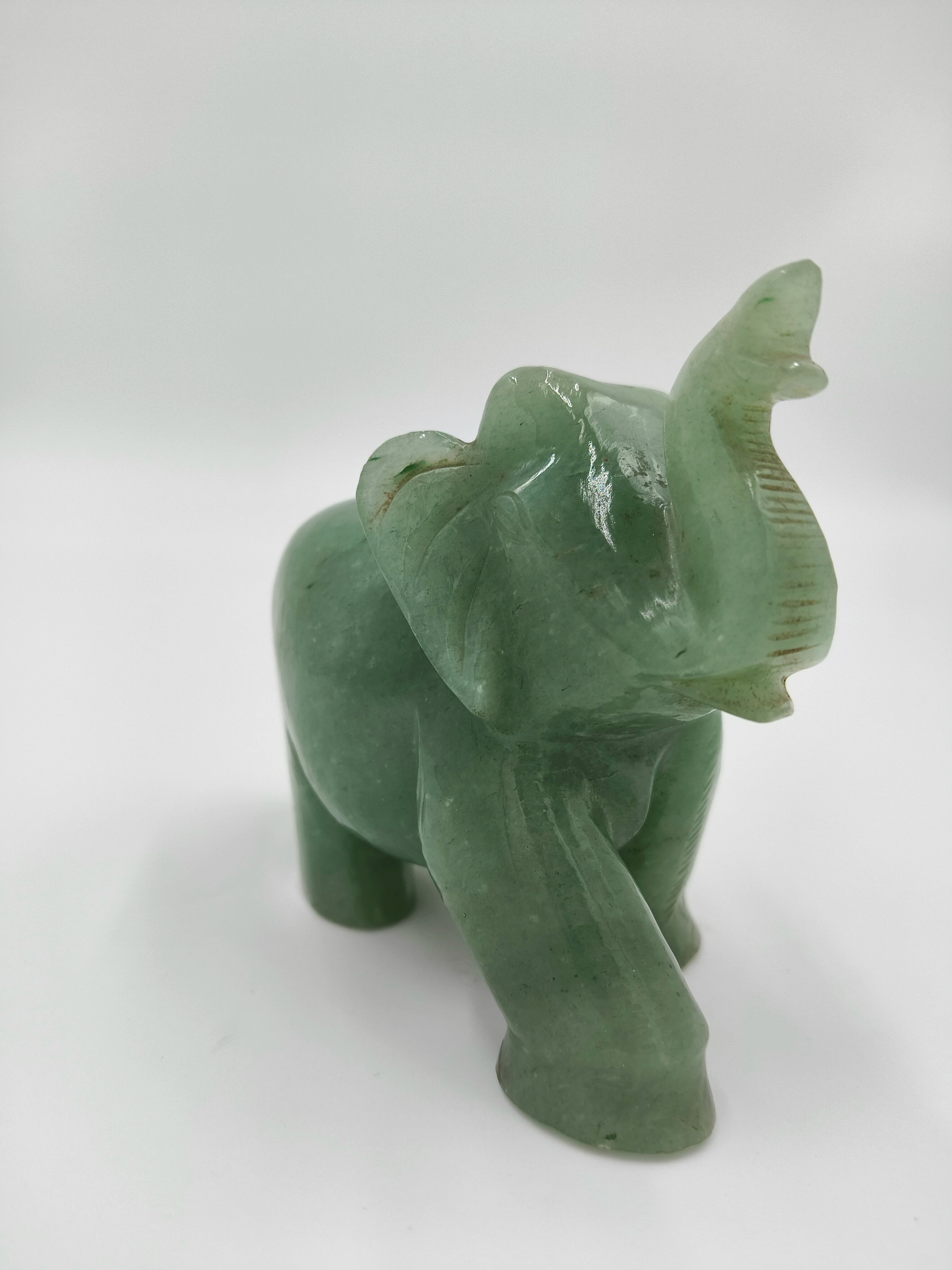 Small green jade elephant sculpture with raised trunk tabletop decor