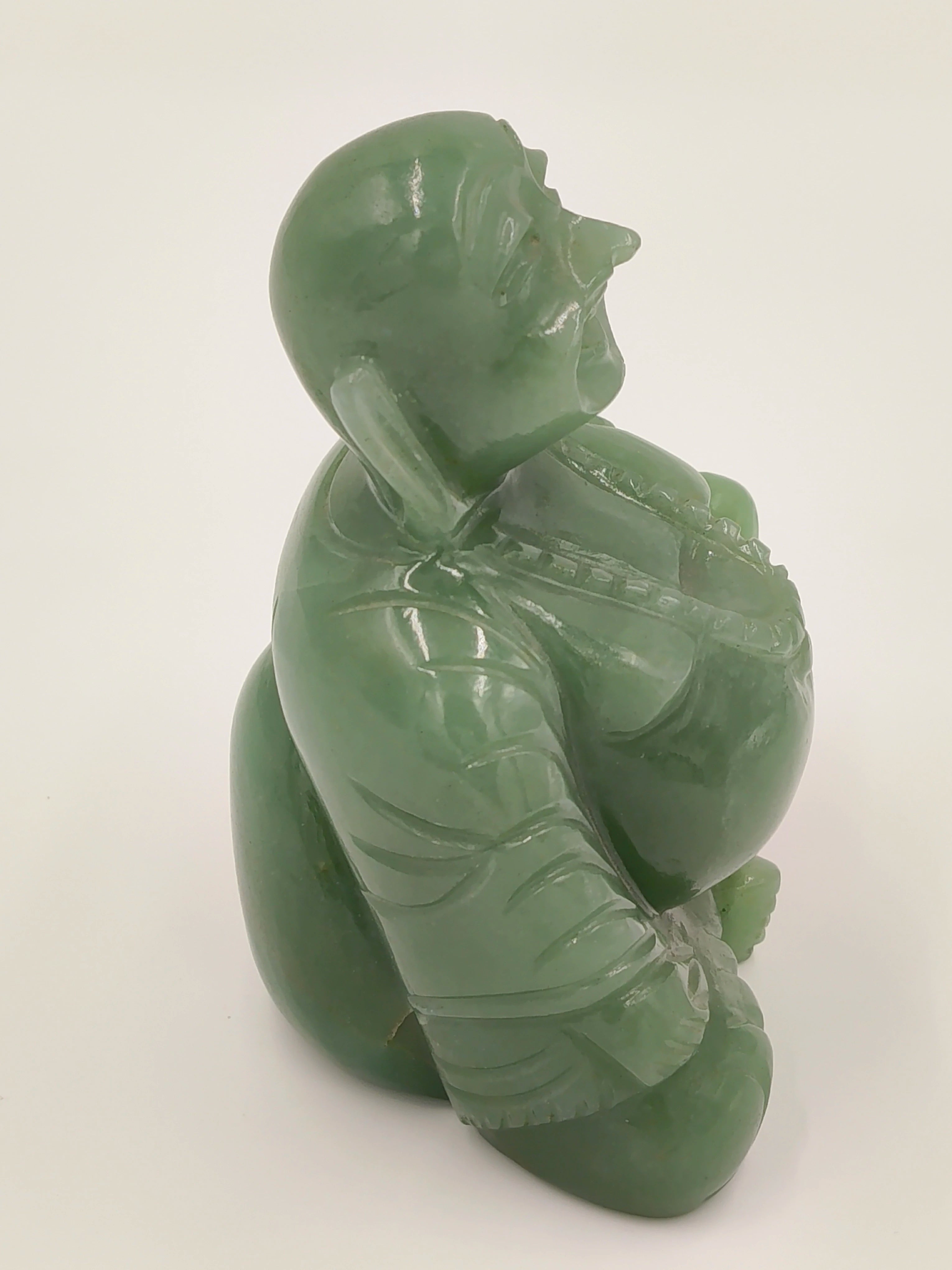 Side view of small jade Laughing Buddha idol with detailed carving