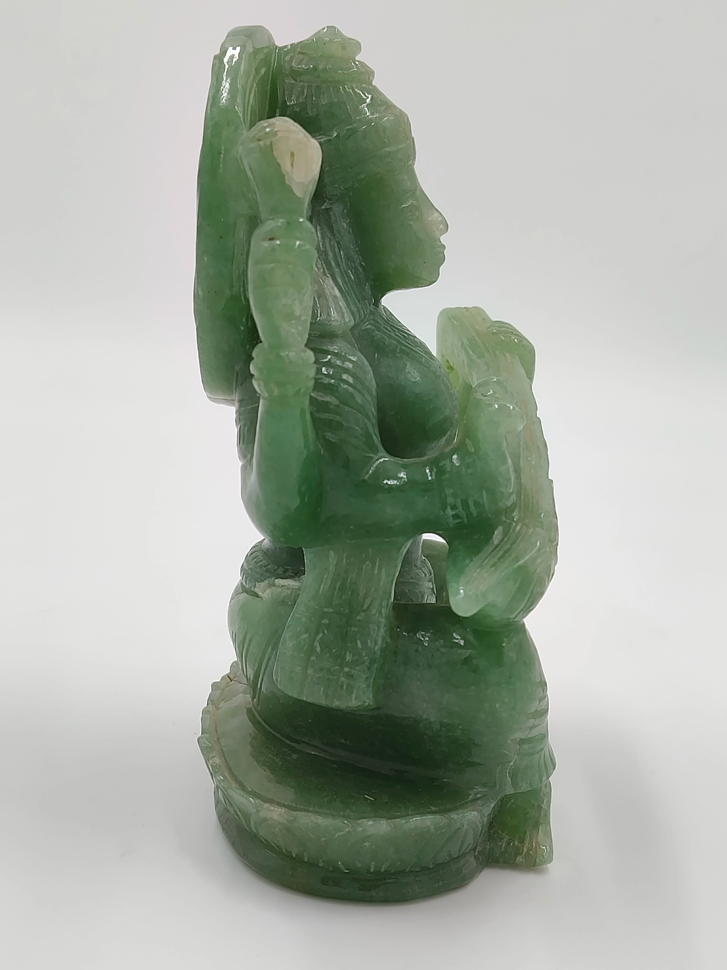 Green jade sculpture of Saraswathi deity in seated pose side view