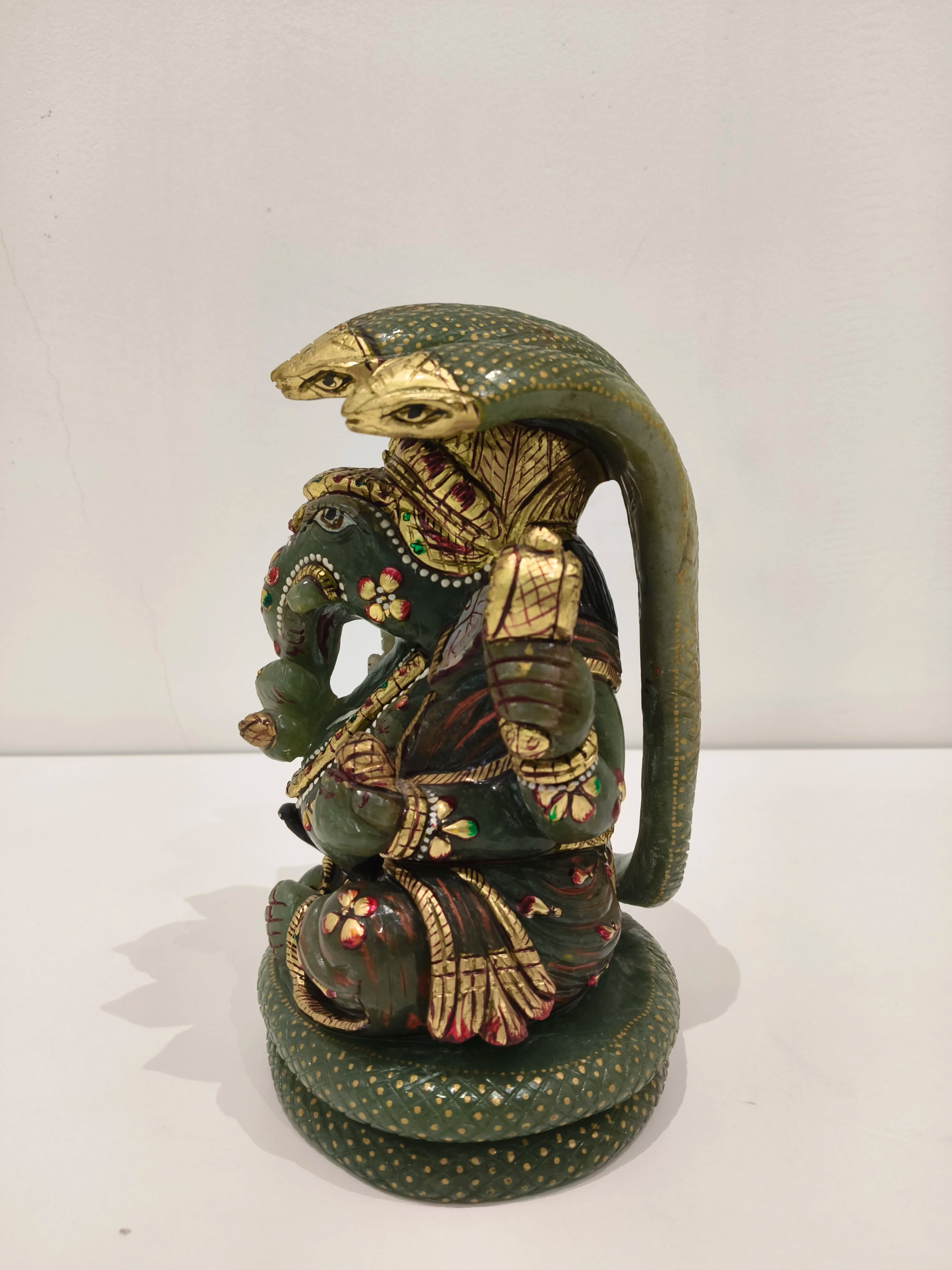 Large jade Ganesh statue with multi-paintings and three-headed cobra hood detail