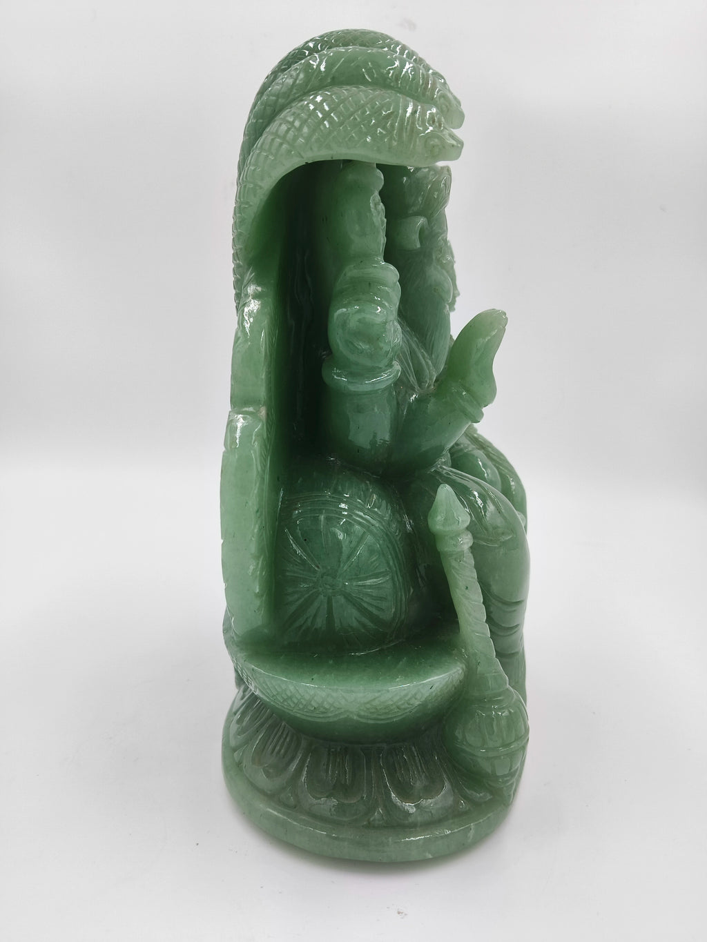 Side view of a green jade sculpture of Lakshmi Narasimha deity with intricate details
