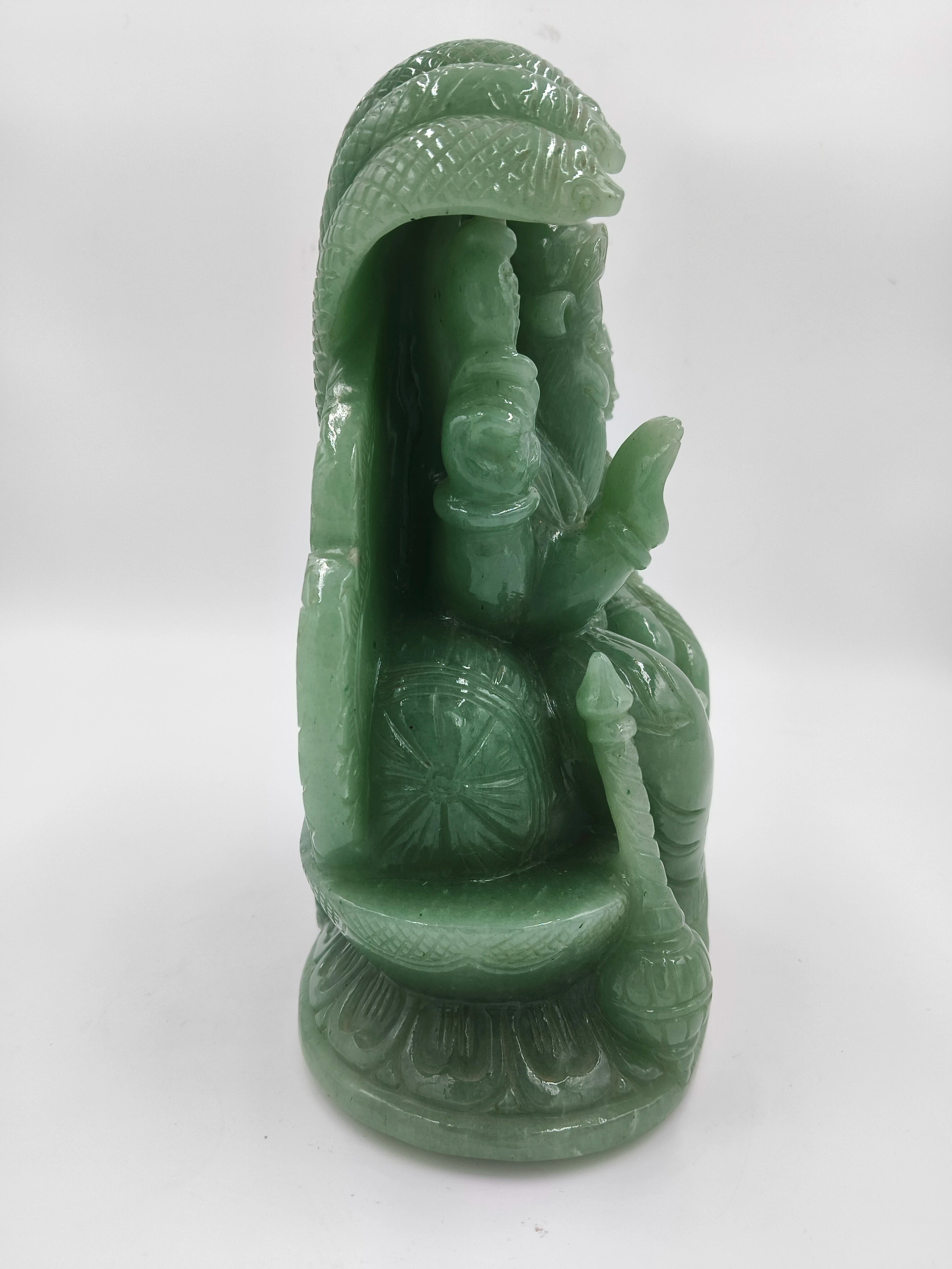 Side view of a green jade sculpture of Lakshmi Narasimha deity with intricate details