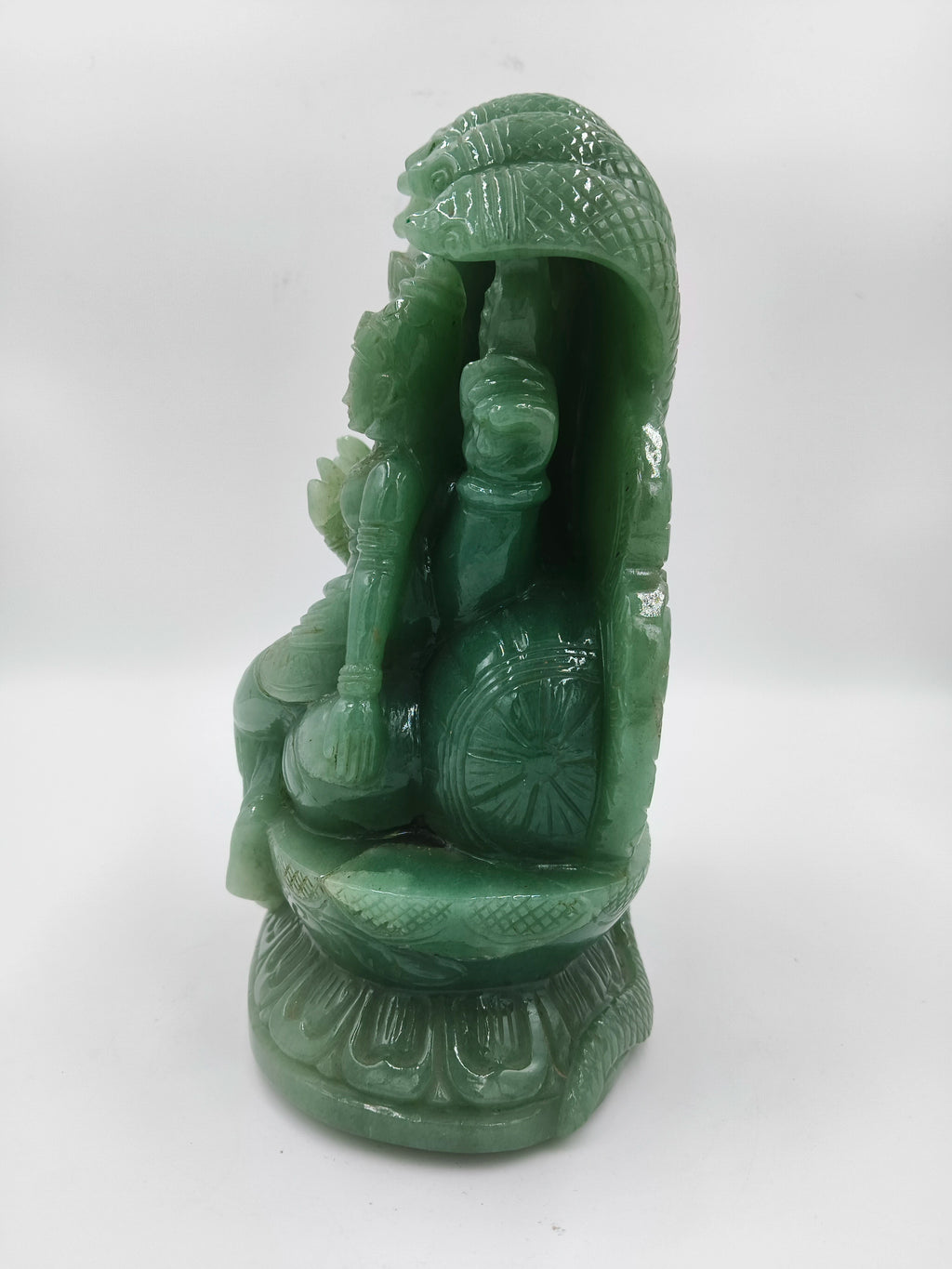 Side view of green jade sculpture depicting Lakshmi Narasimha deity on pedestal