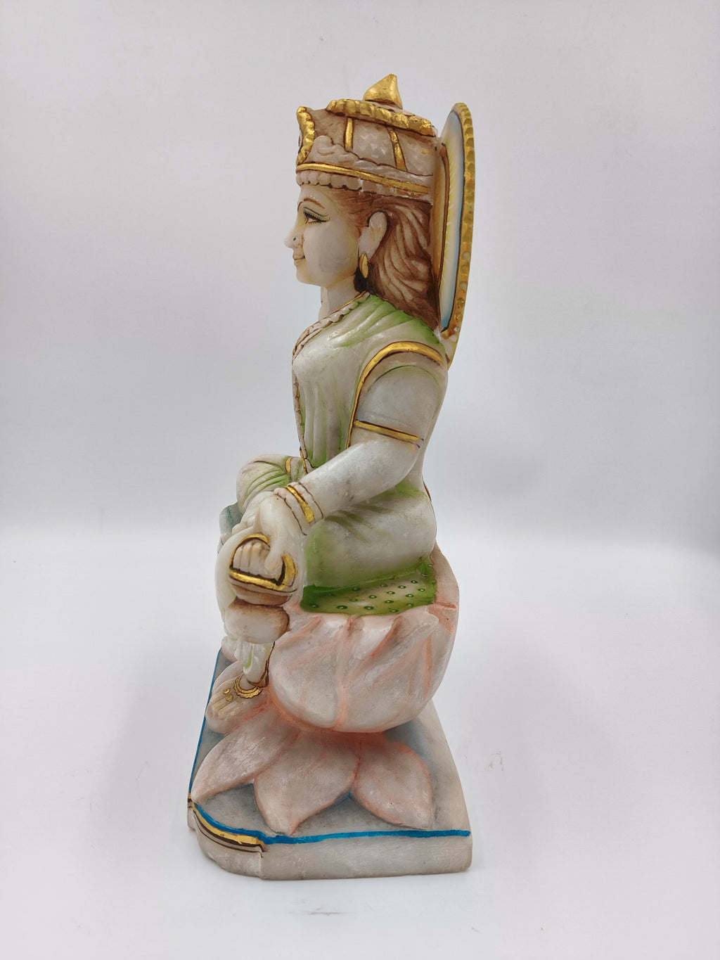 Side view of marble Gayatri sculpture seated on lotus pedestal with gold accents
