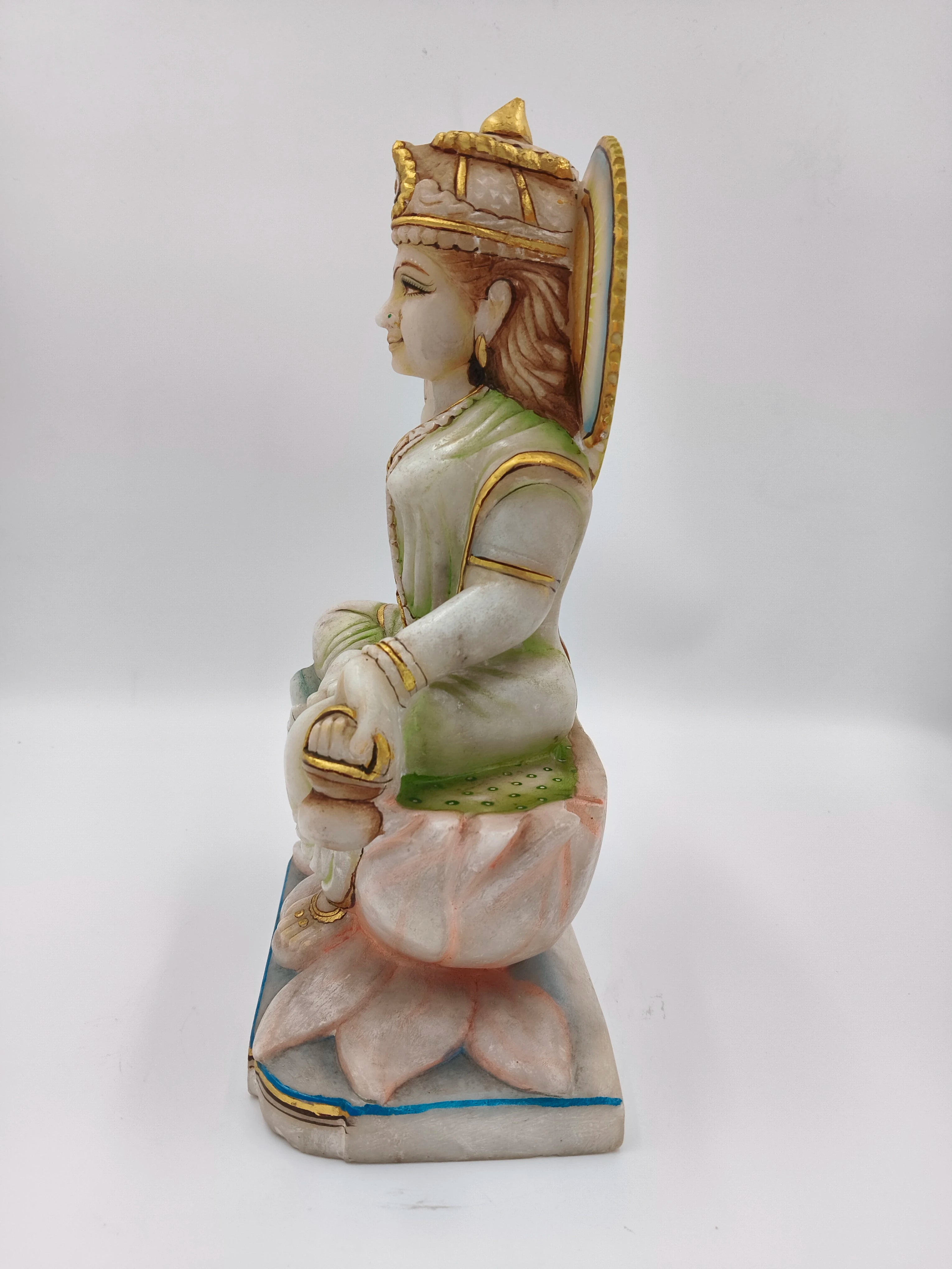 Side view of marble Gayatri sculpture seated on lotus pedestal with gold accents