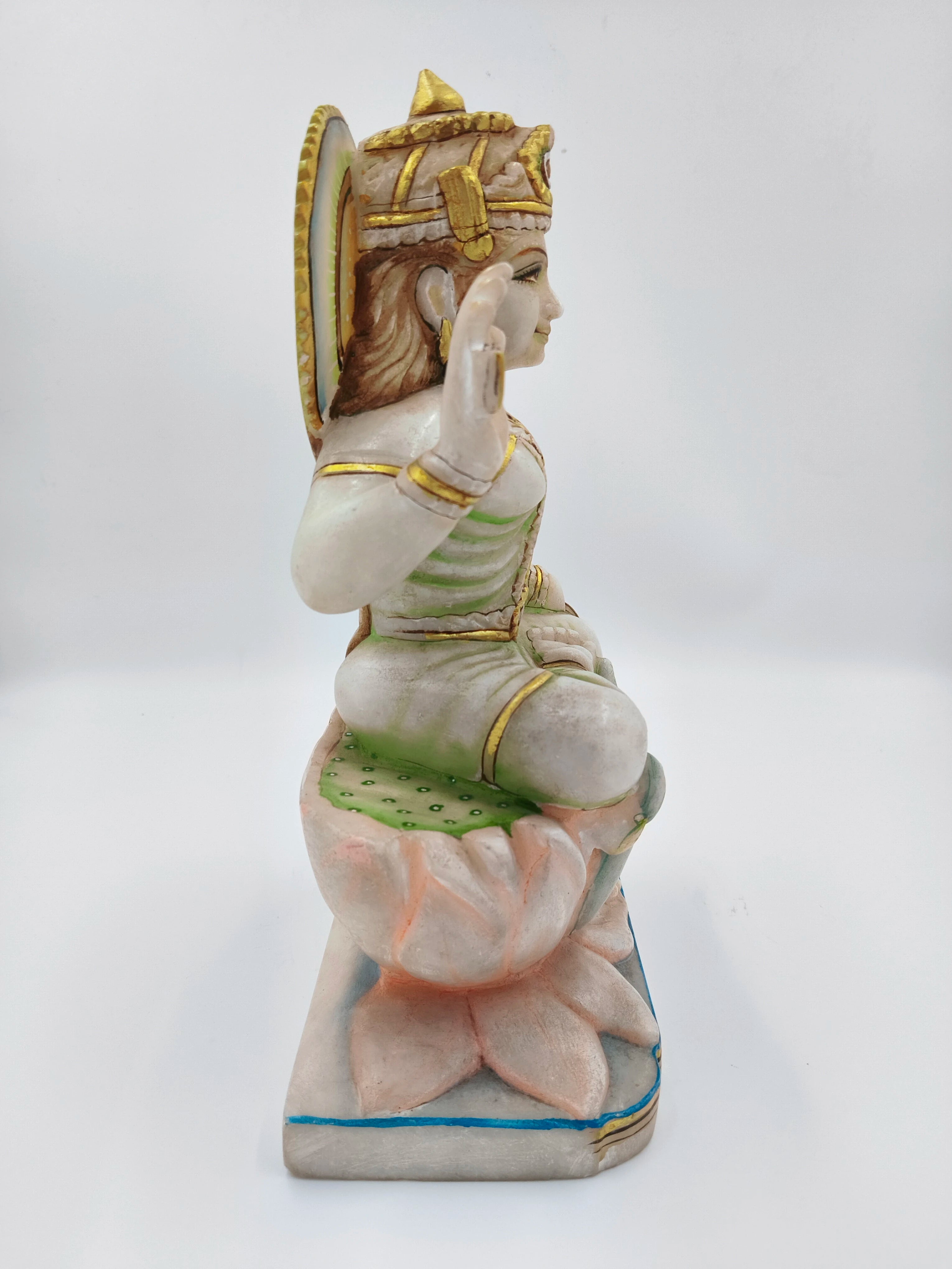 Side view of large marble Gayatri sculpture seated on lotus base with gold accents