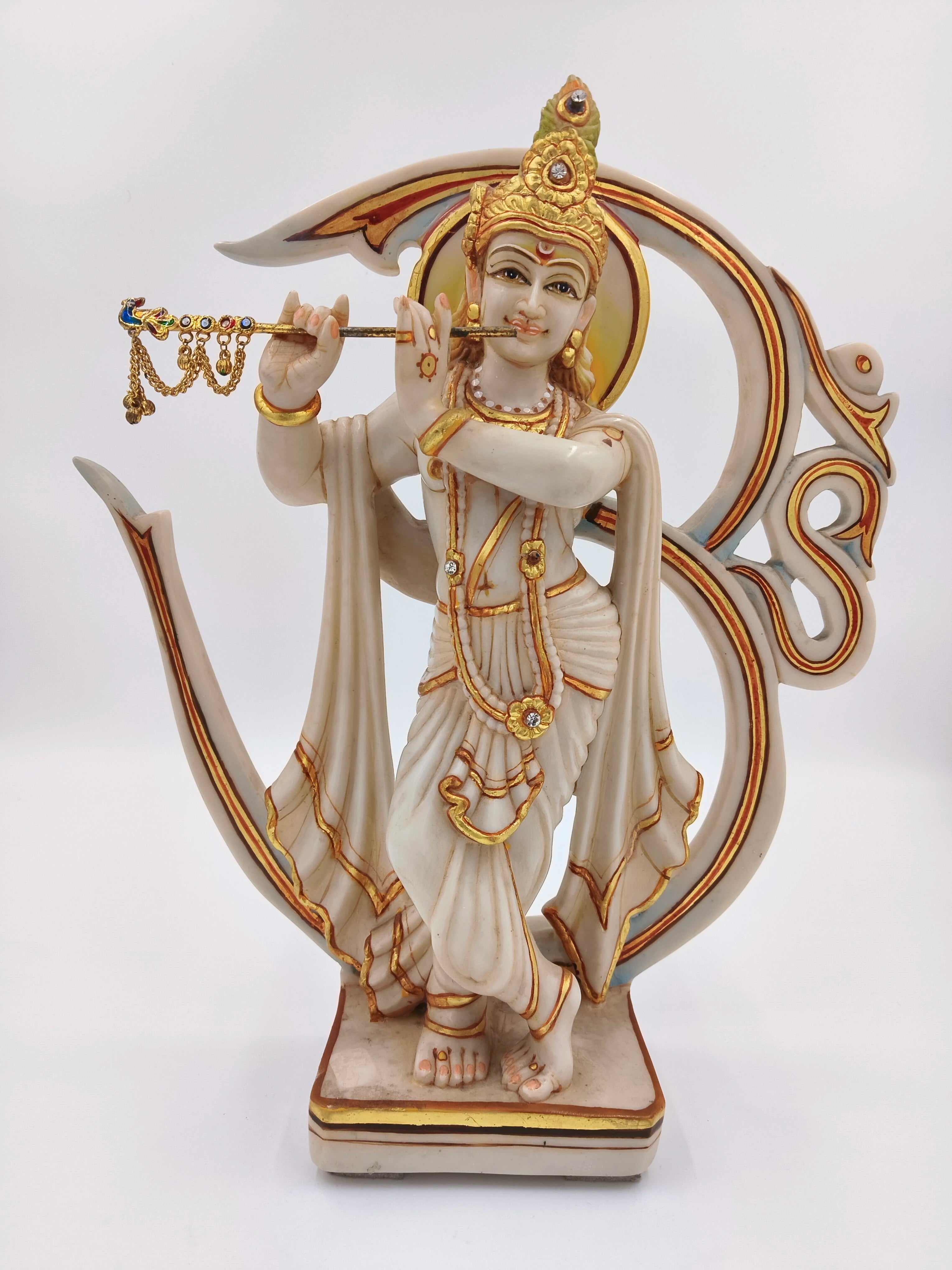 Marble dust Krishna sculpture playing flute with Aum symbol backdrop