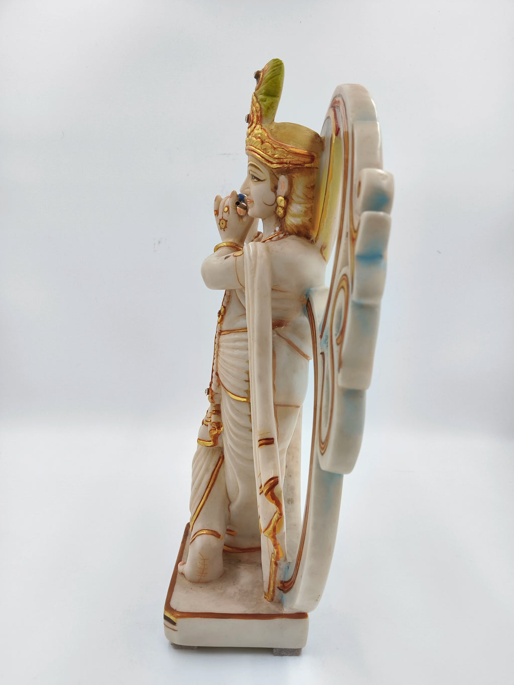 Side view of large marble dust Krishna statue playing flute with Aum symbol