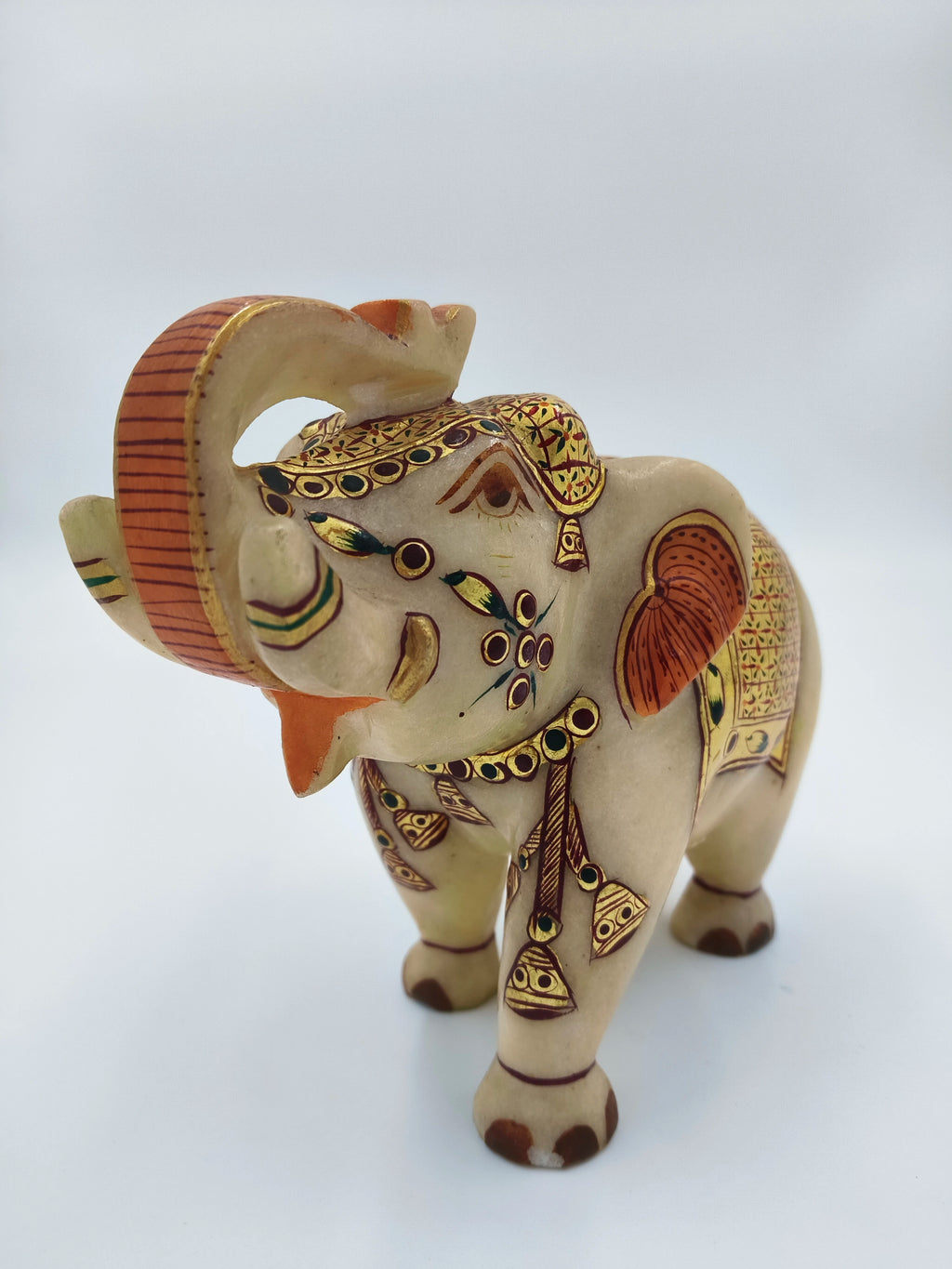 Hand-painted marble elephant sculpture with decorative patterns and bells