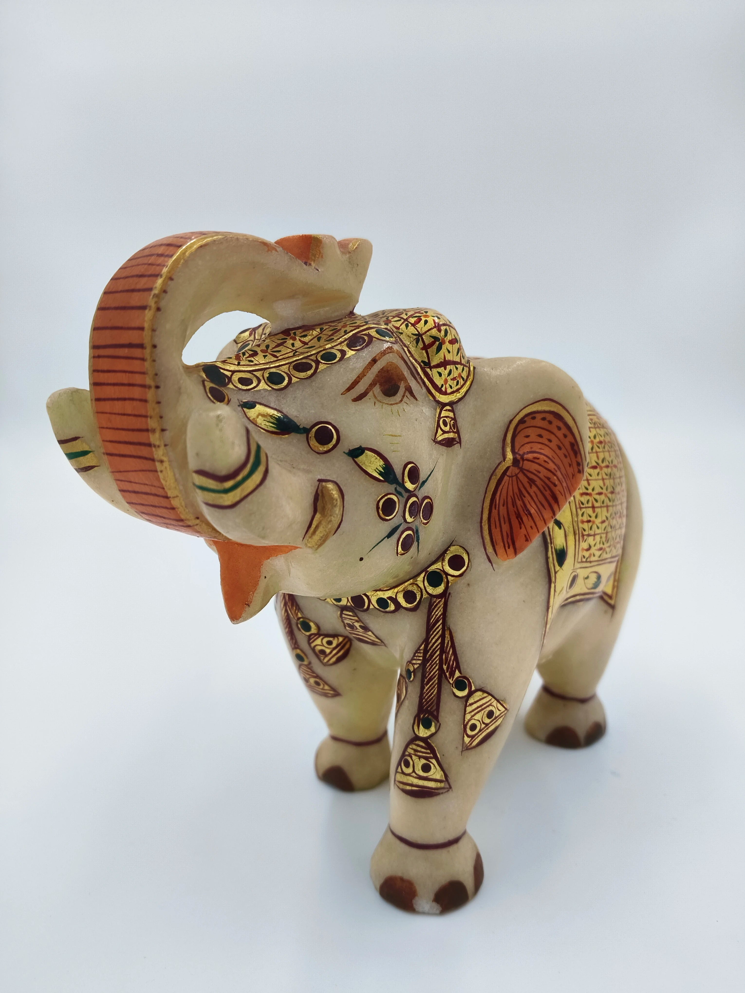 Hand-painted marble elephant sculpture with decorative patterns and bells