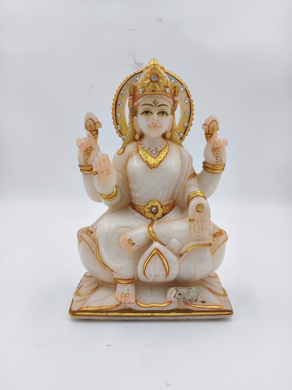 White marble statue of Lakshmi goddess with gold and rhinestone accents, seated on lotus