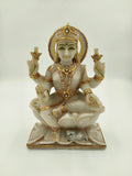 Front view of marble Lakshmi statue with gold and jewel accents seated on lotus