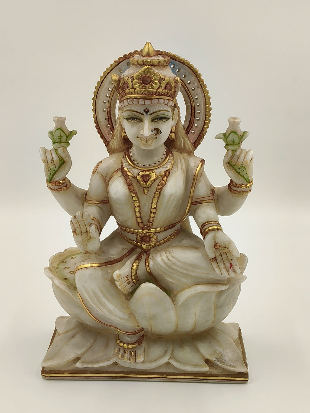 Front view of a 10.2 inch white marble Lakshmi statue seated on a lotus