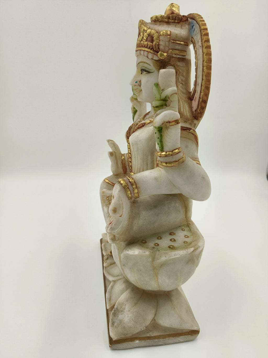 Side view of a 10.2 inch marble Lakshmi statue with gold and green accents