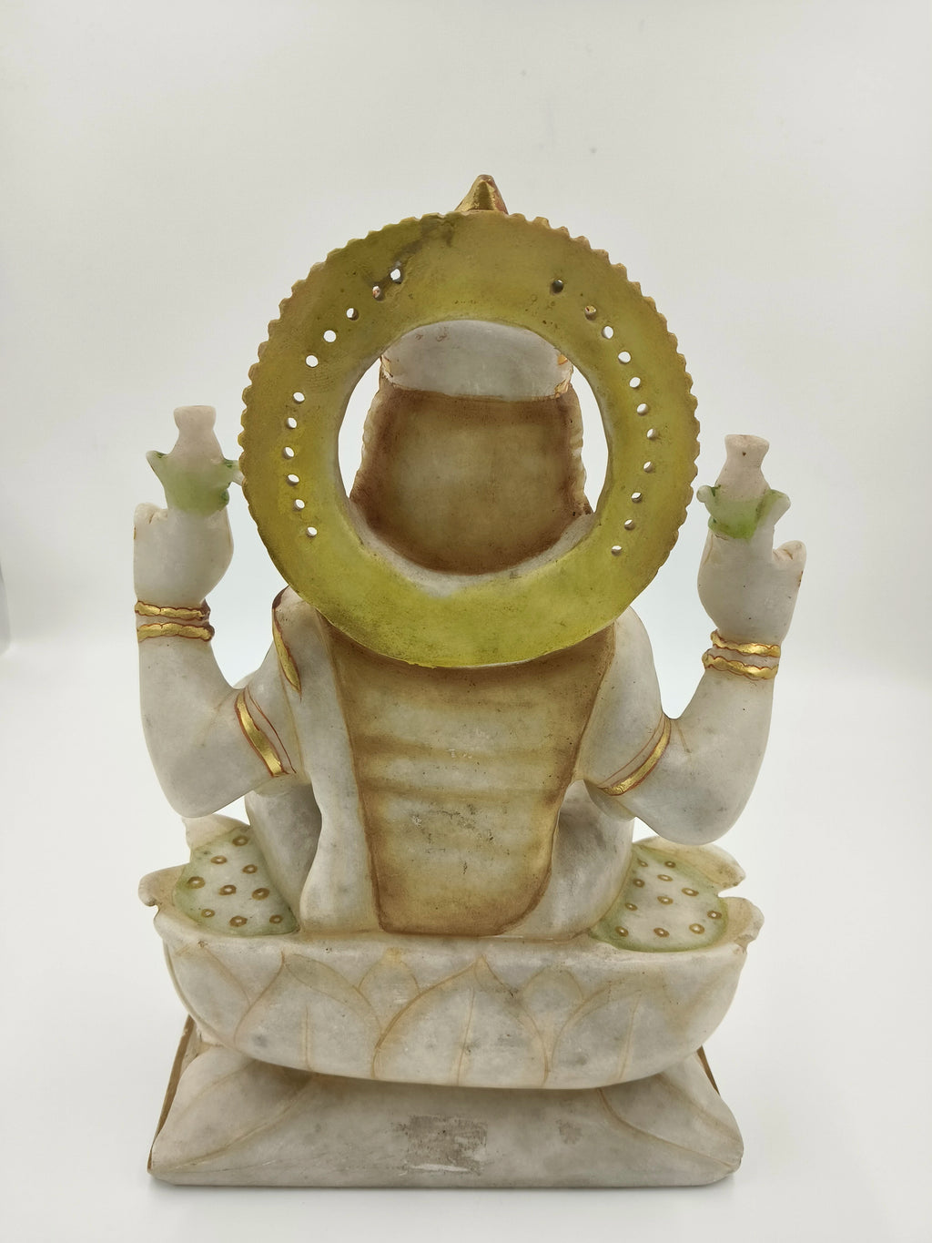 Back view of marble Lakshmi statue with golden halo and adorning details