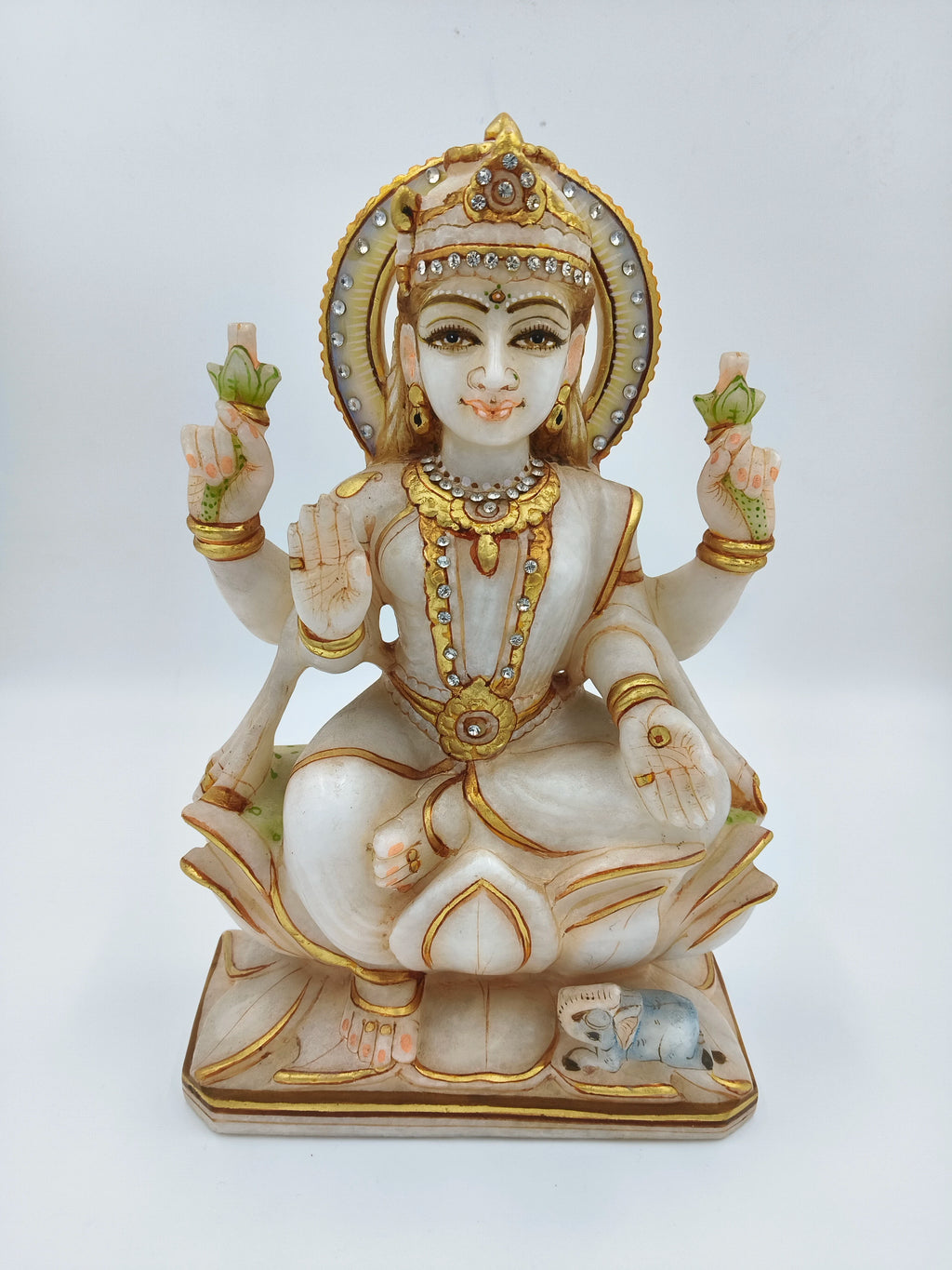 Marble sculpture of seated Lakshmi goddess with gold and gem accents