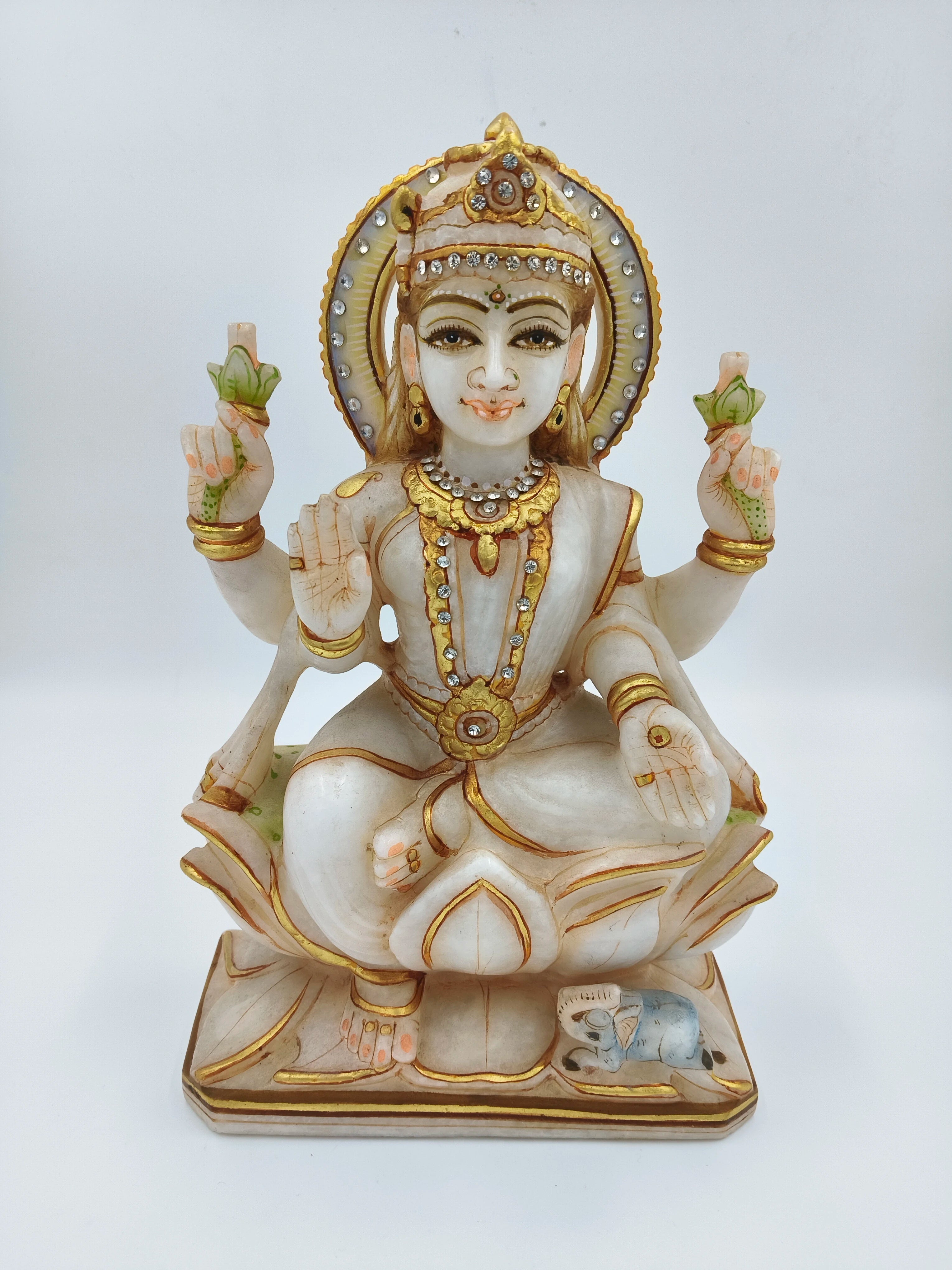 Marble sculpture of seated Lakshmi goddess with gold and gem accents