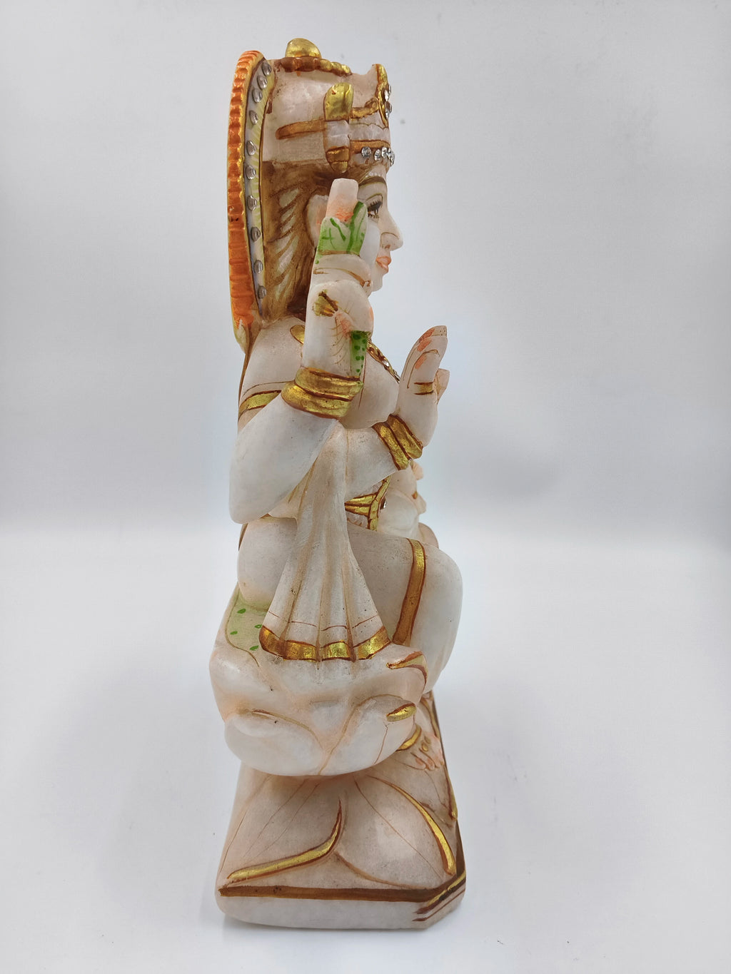 Side view of 11-inch marble Lakshmi sculpture with gold and green accents