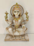Large marble statue of Lakshmi goddess seated on lotus with gold accents