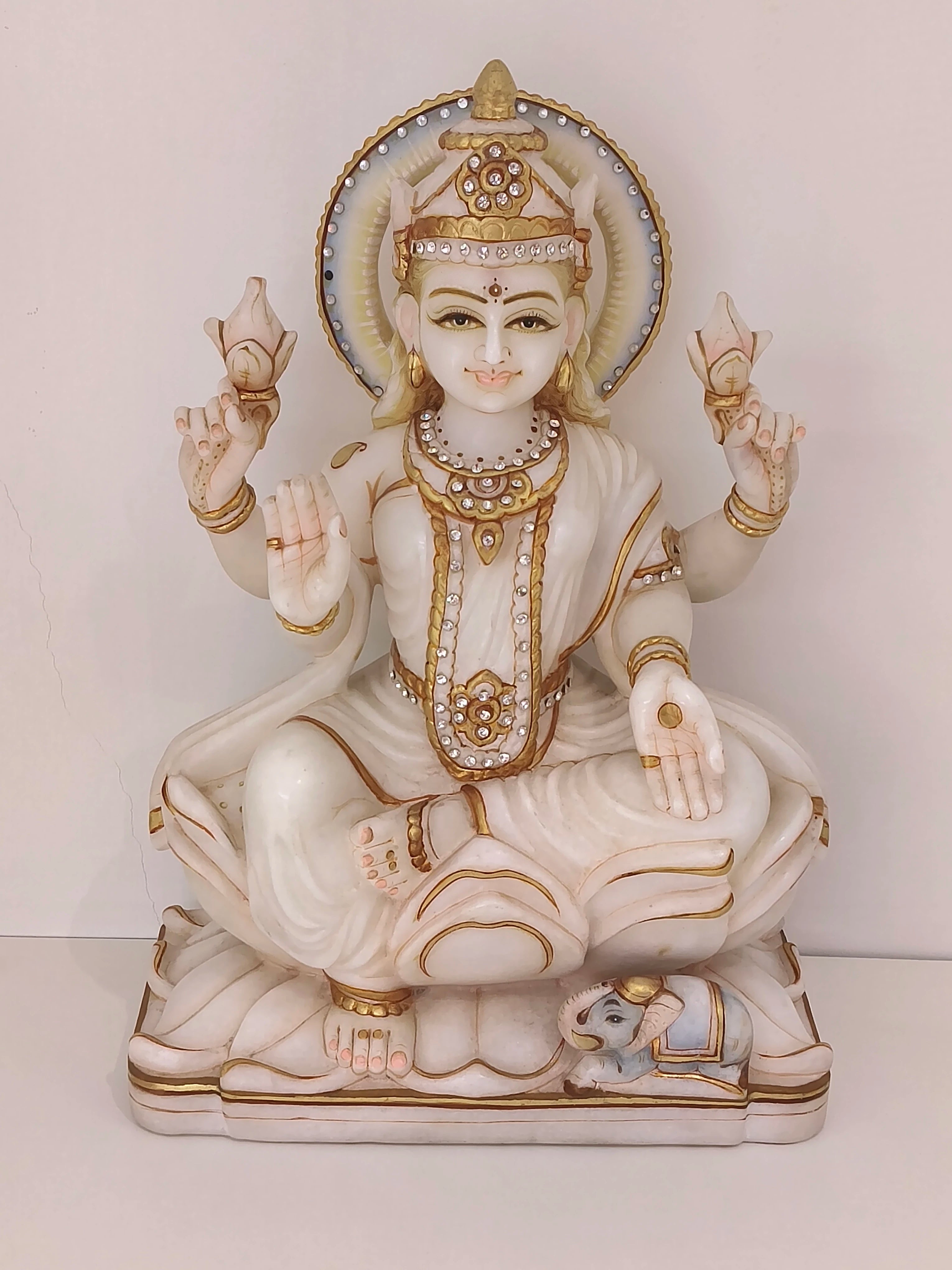 Marble statue of Goddess Lakshmi seated with four arms holding lotus flowers